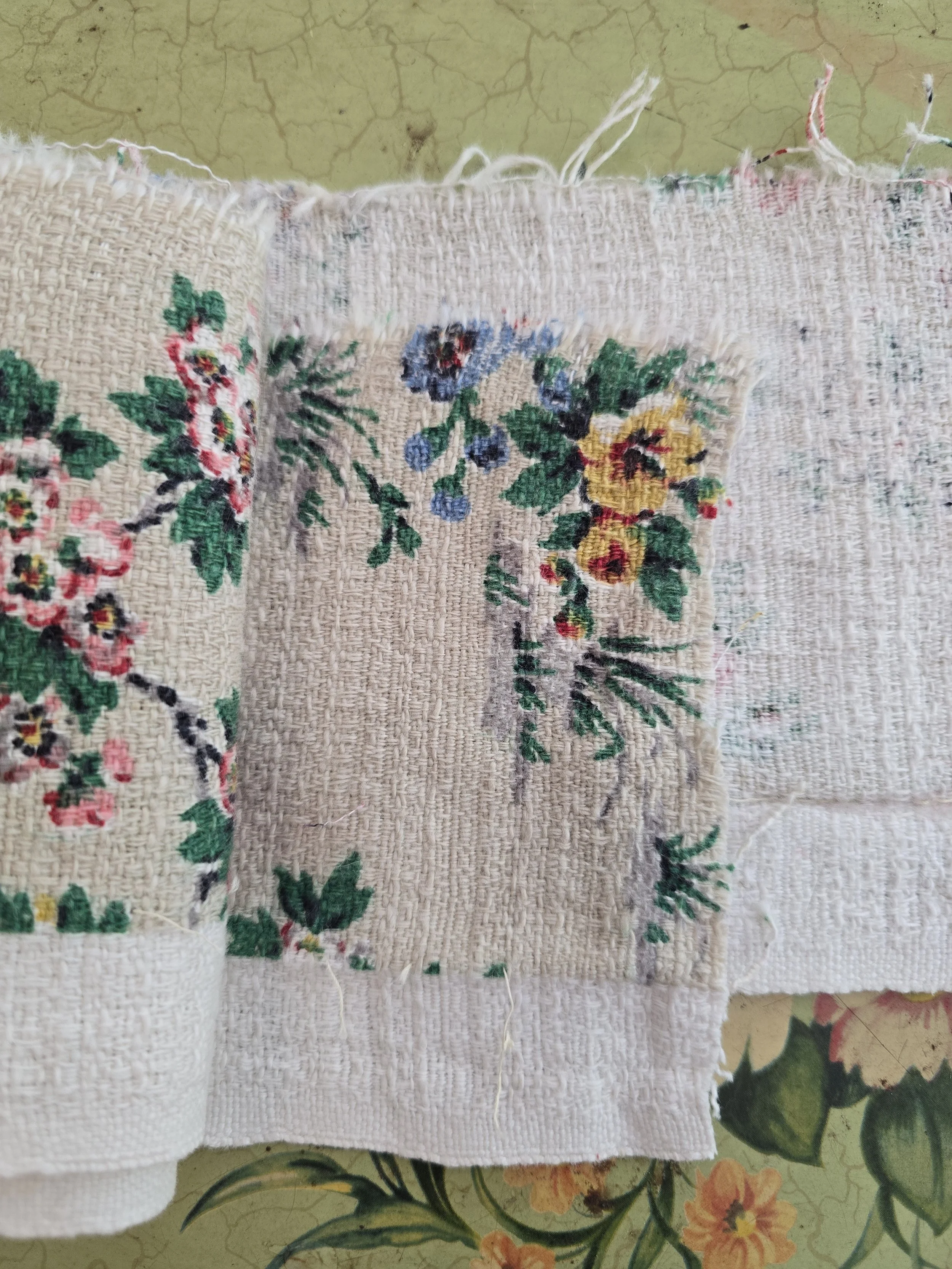Soft faded floral textile fragment with frayed edges and wear