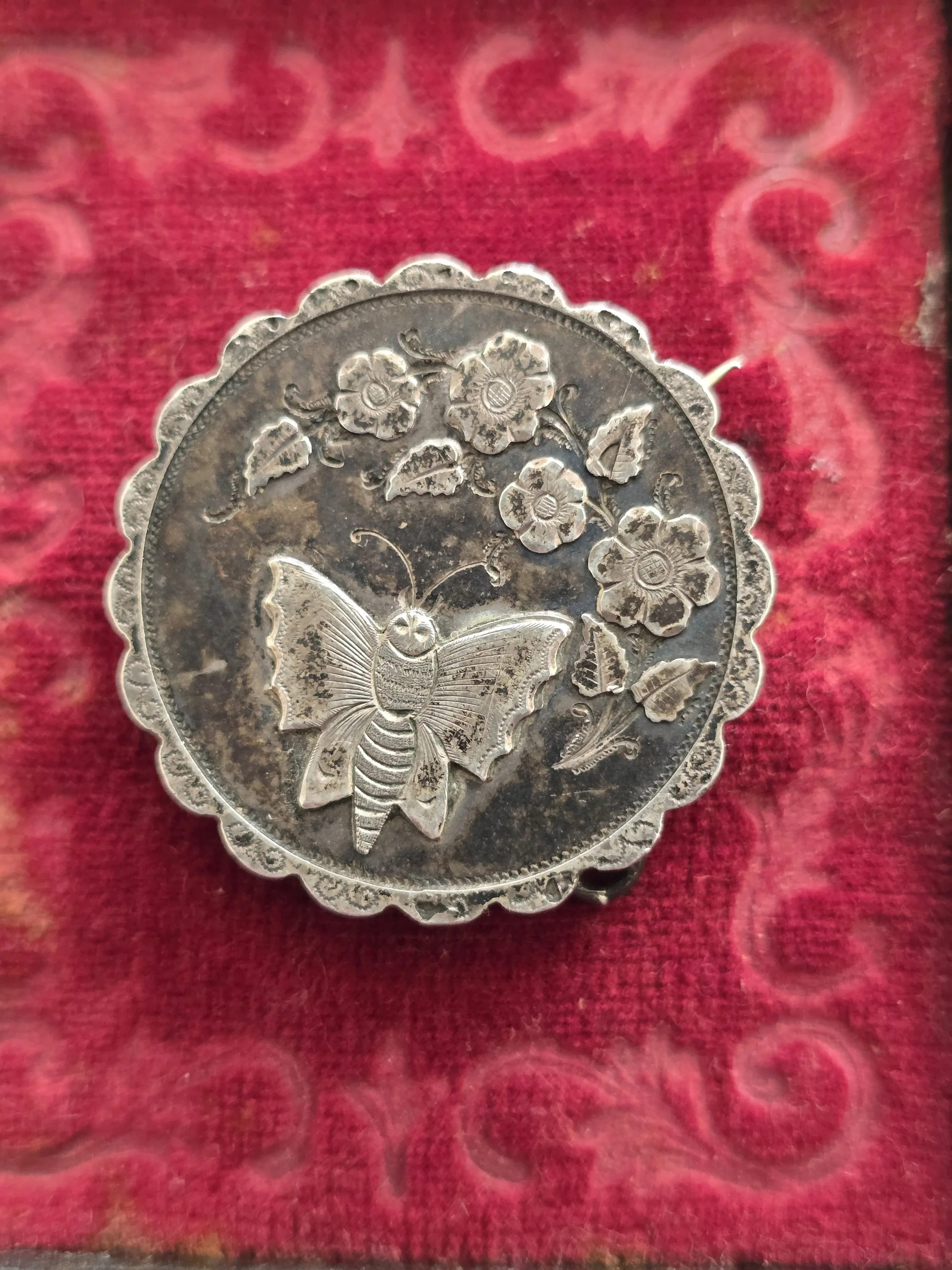 Antique sterling silver butterfly brooch pendant with floral decoration and glazed compartment.