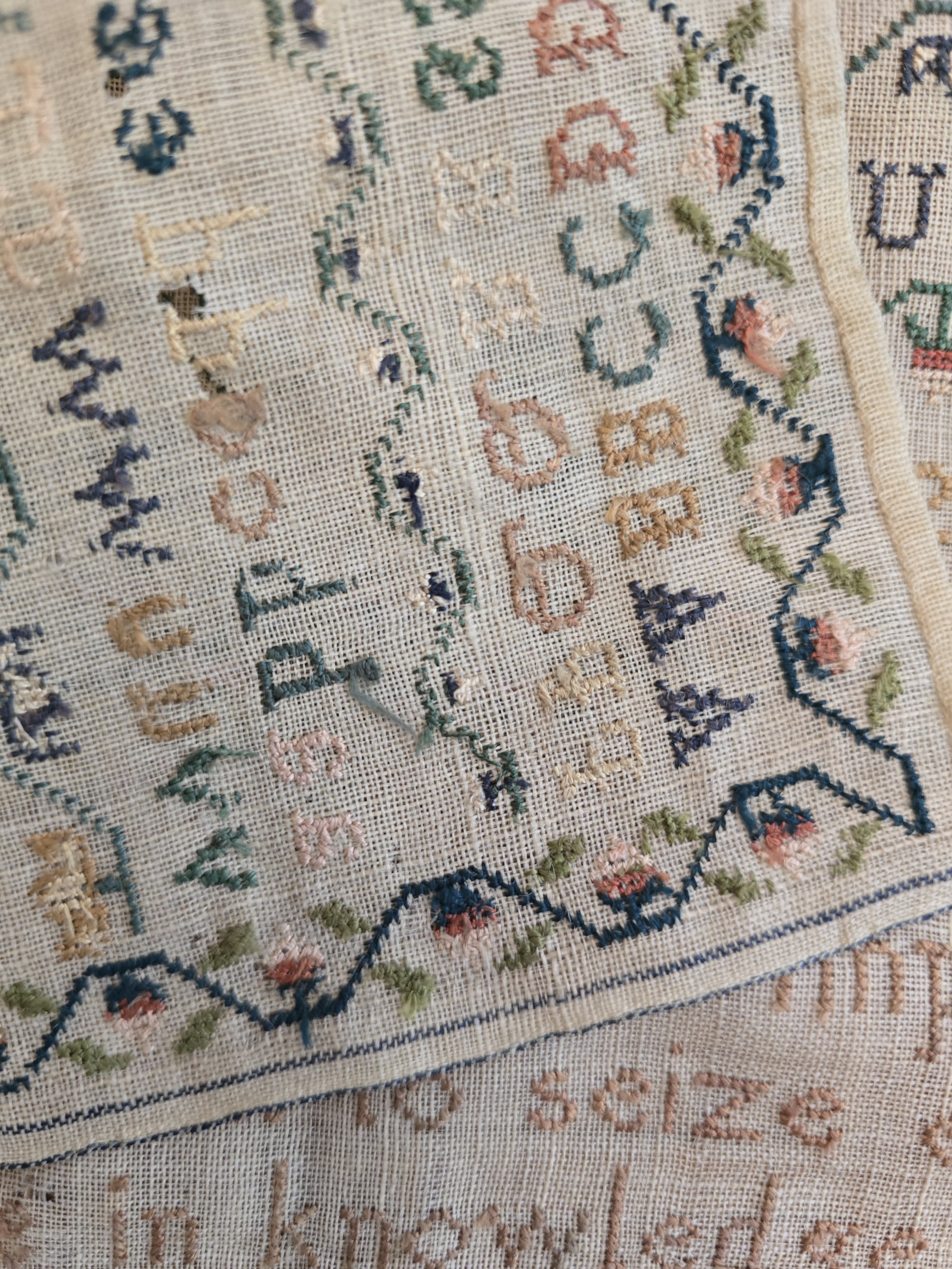 Close-up of age-related wear and losses to the linen, consistent with a sampler approaching two hundred years old.