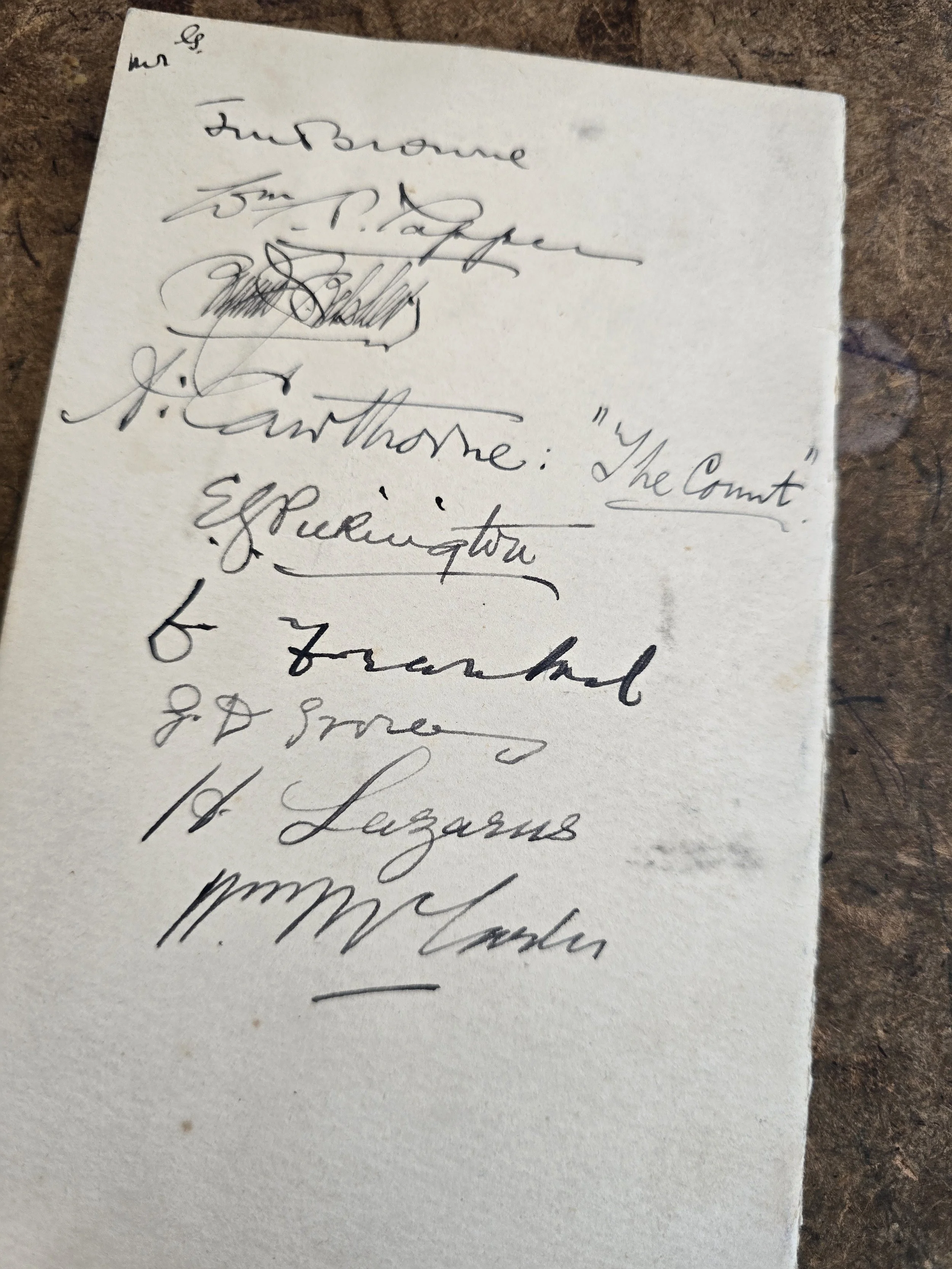 Interior of vintage French menu card showing guest names and courses.