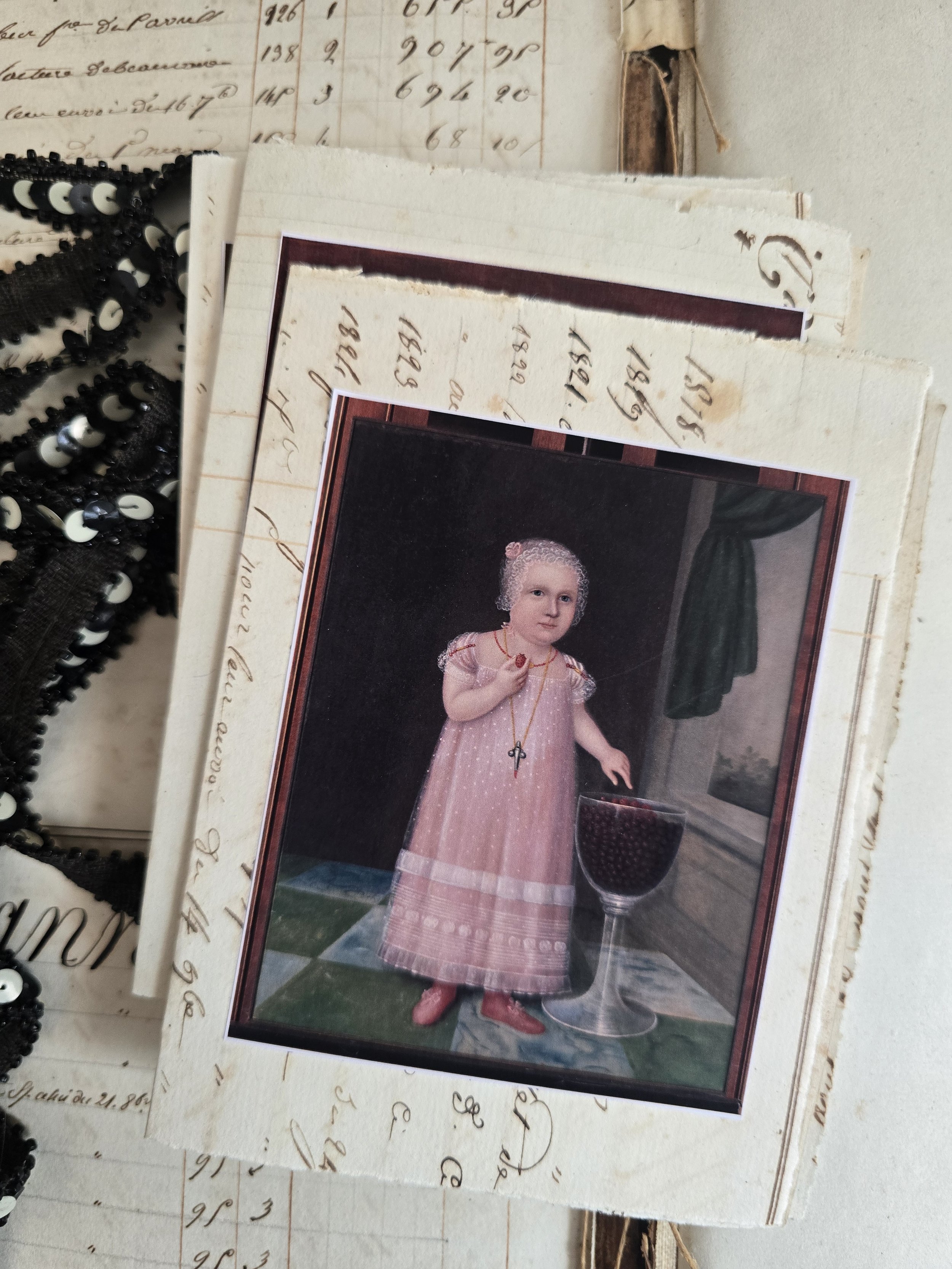 Handmade card featuring a young girl holding a bird, mounted onto genuine French ledger paper dating from 1829.
