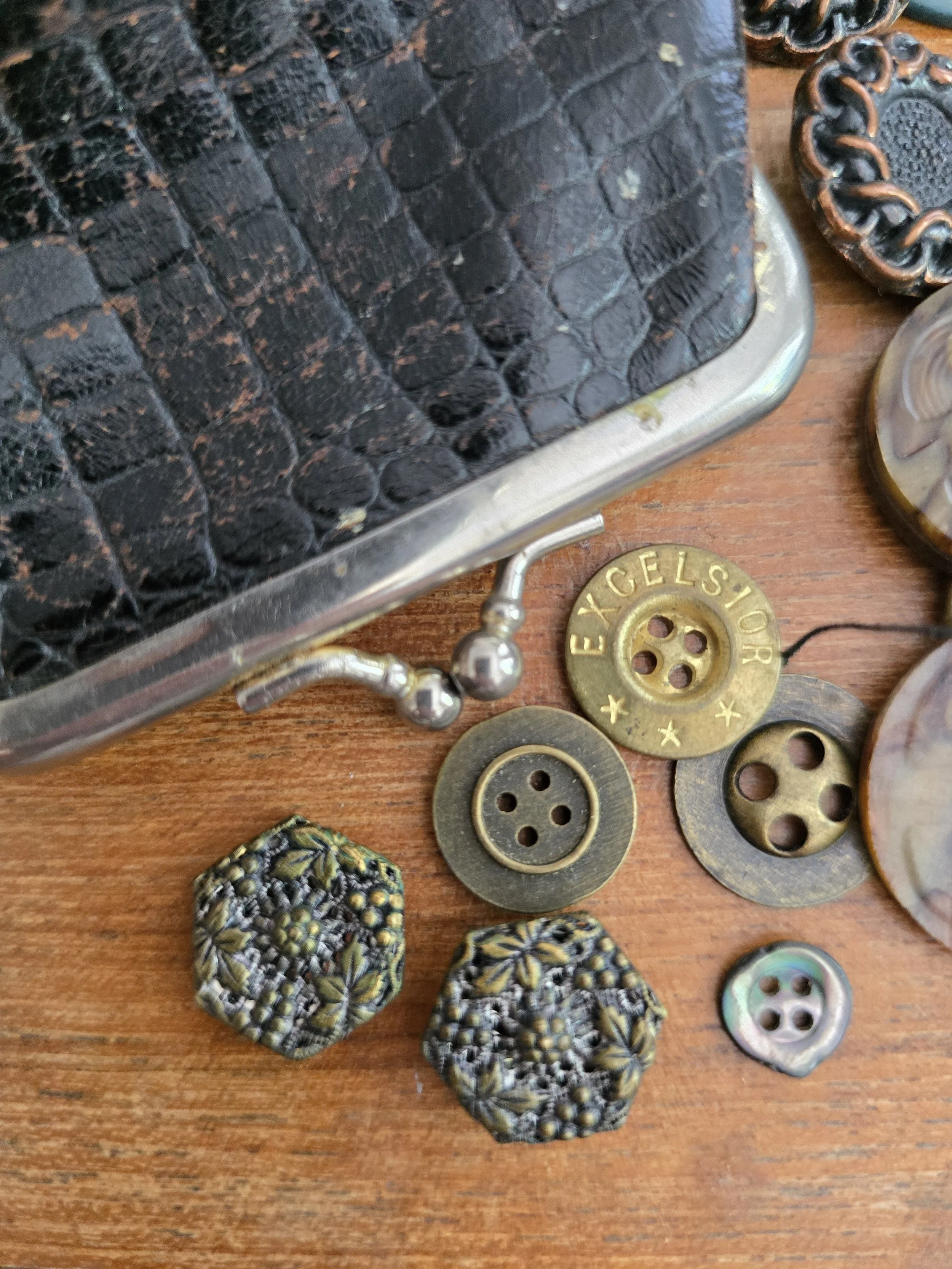 Pair of antique hexagonal openwork metal buttons with raised floral and berry decoration.