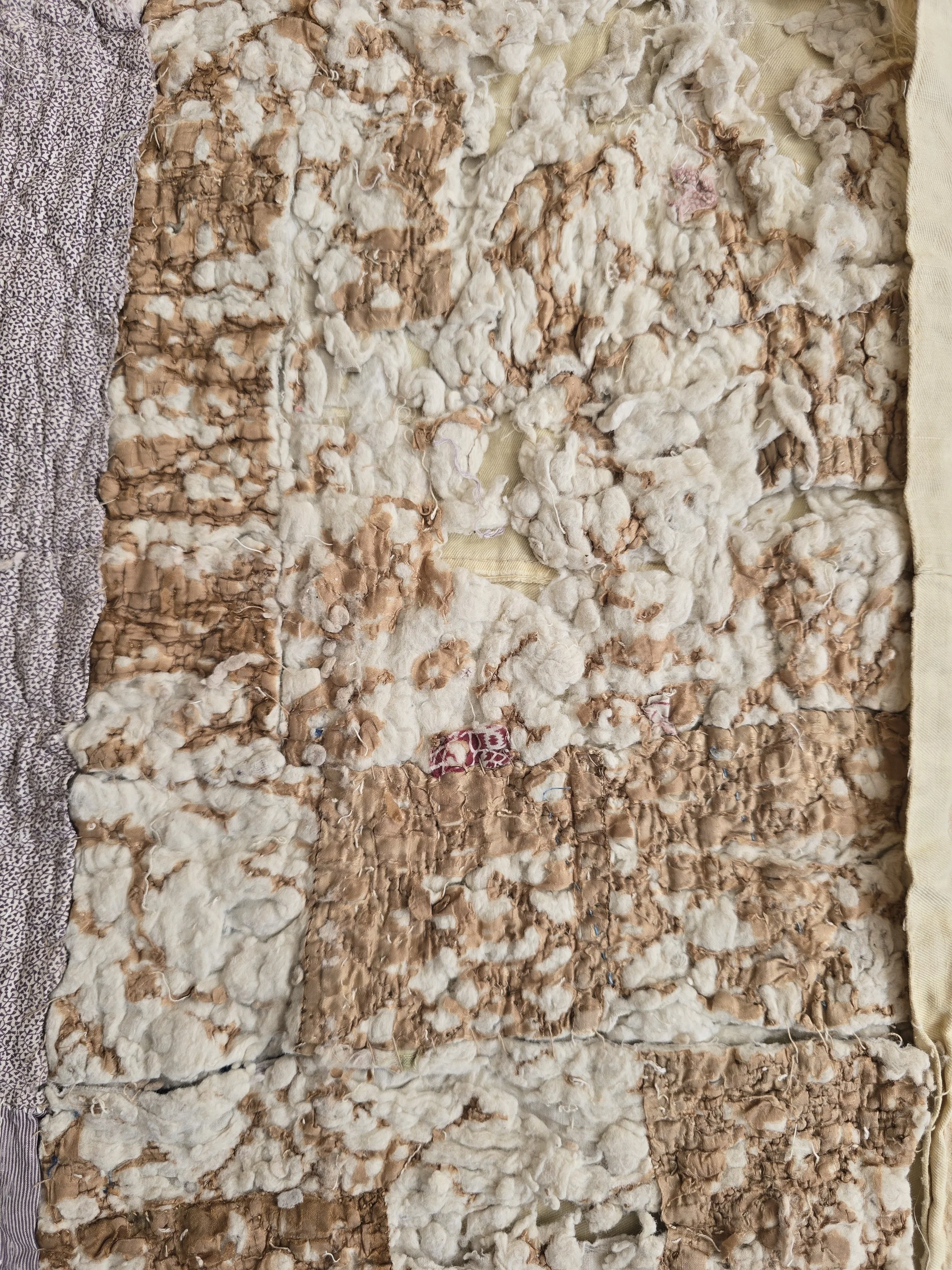 Detail of 19th century French quilt showing tiny purple cotton and hand quilting.