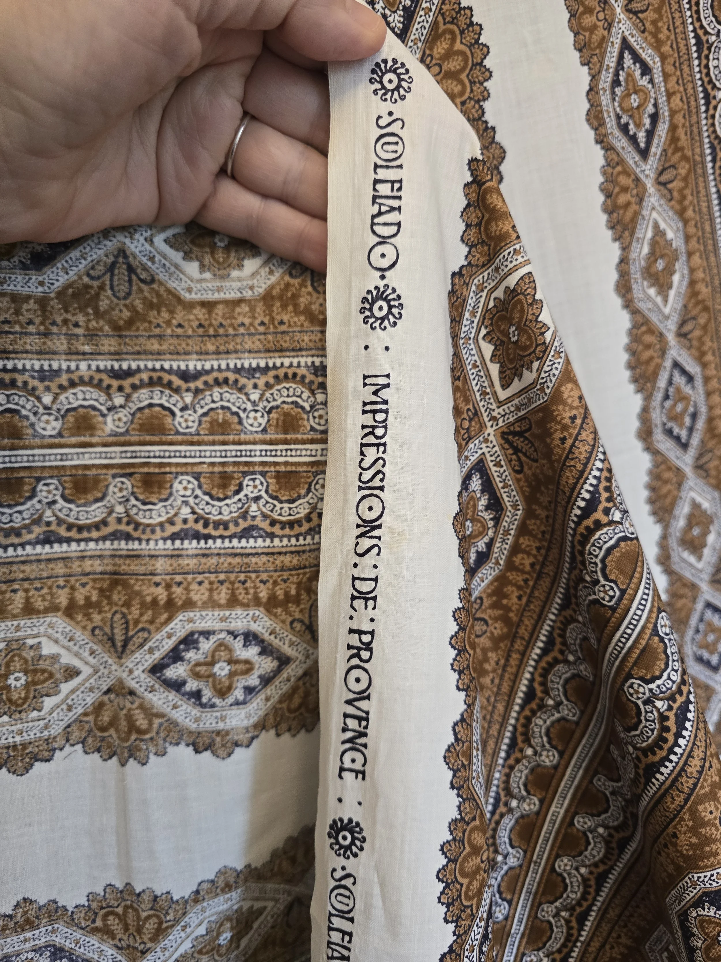 Close view of Souleiado fabric showing geometric floral bands on a cream ground.