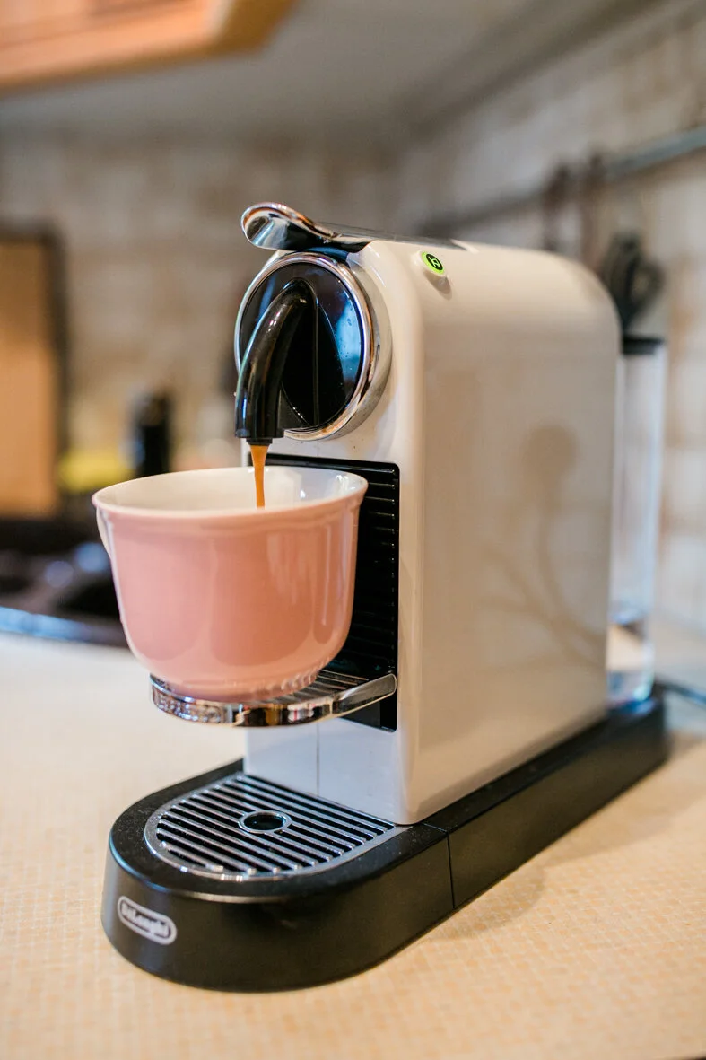 Nespresso Kaffeemaschine brüht Kaffee in eine traditionelle rosa Kaffeetasse