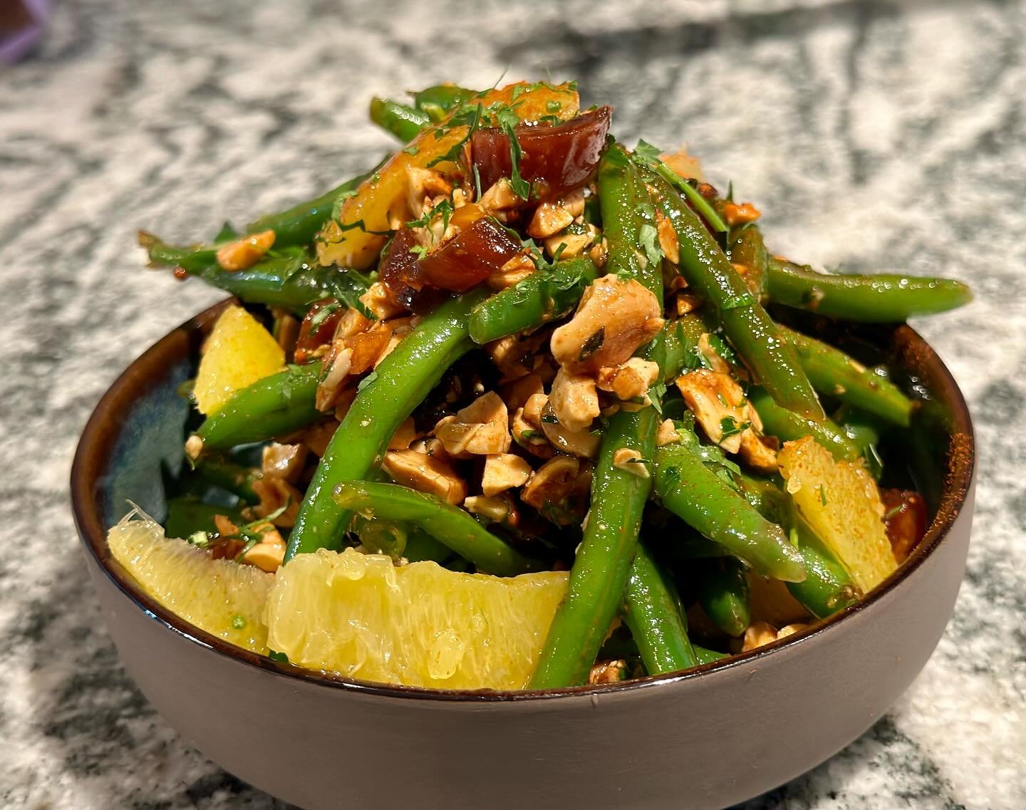 This my favorite Thanksgiving side dish to cut through all of the rich dishes that we all eat during this festive Holiday.  Fresh cut/blanched Green Beans with, orange segments, dates and toasted marcona almonds tossed in a sherry shallot vinaigrette