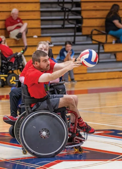 Titan Matthew Thompson throwing the ball at a Titan scrimmage game. 7. Champions Place@Home recipient, Carria Williams, smiling with some of her new technology from the CP@Home program.