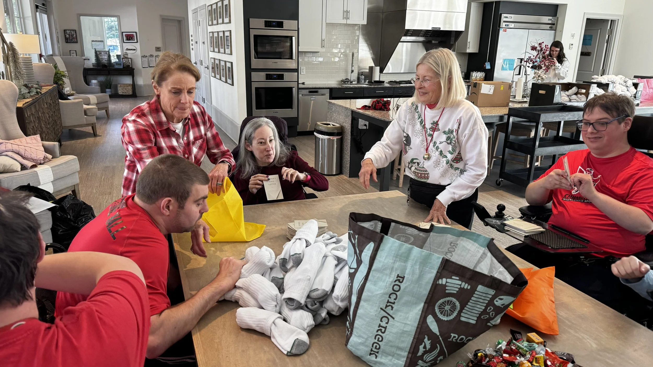 Champions Place residents: Tim, Ashley and Matt working with volunteers to pack the bags.