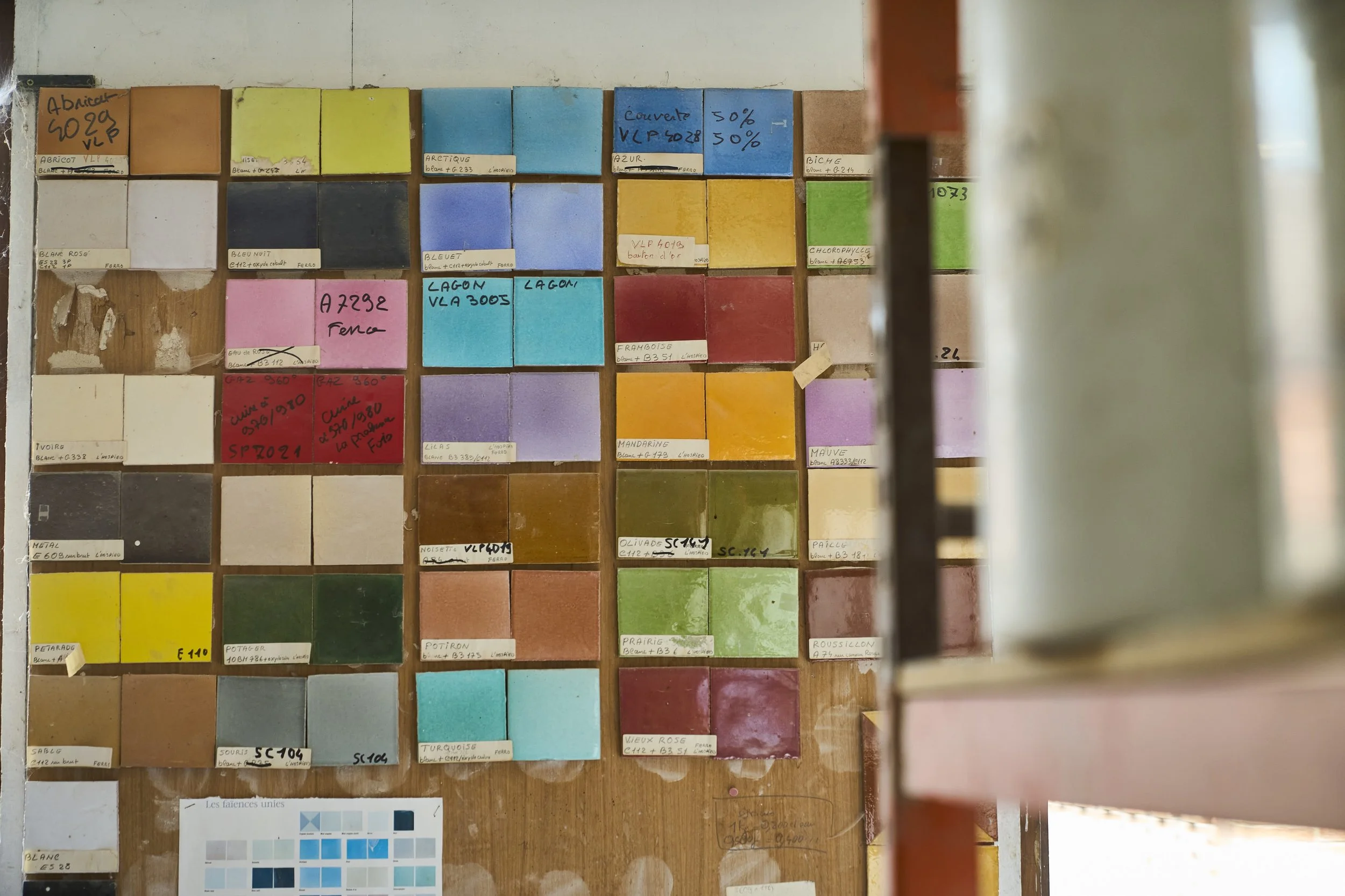 A workshop image of ceramic tile colours and handwritten colour codes