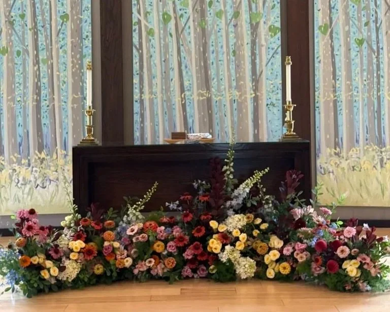 a floral meadow in front of a church altar and cross with a beautiful painted backdrop
