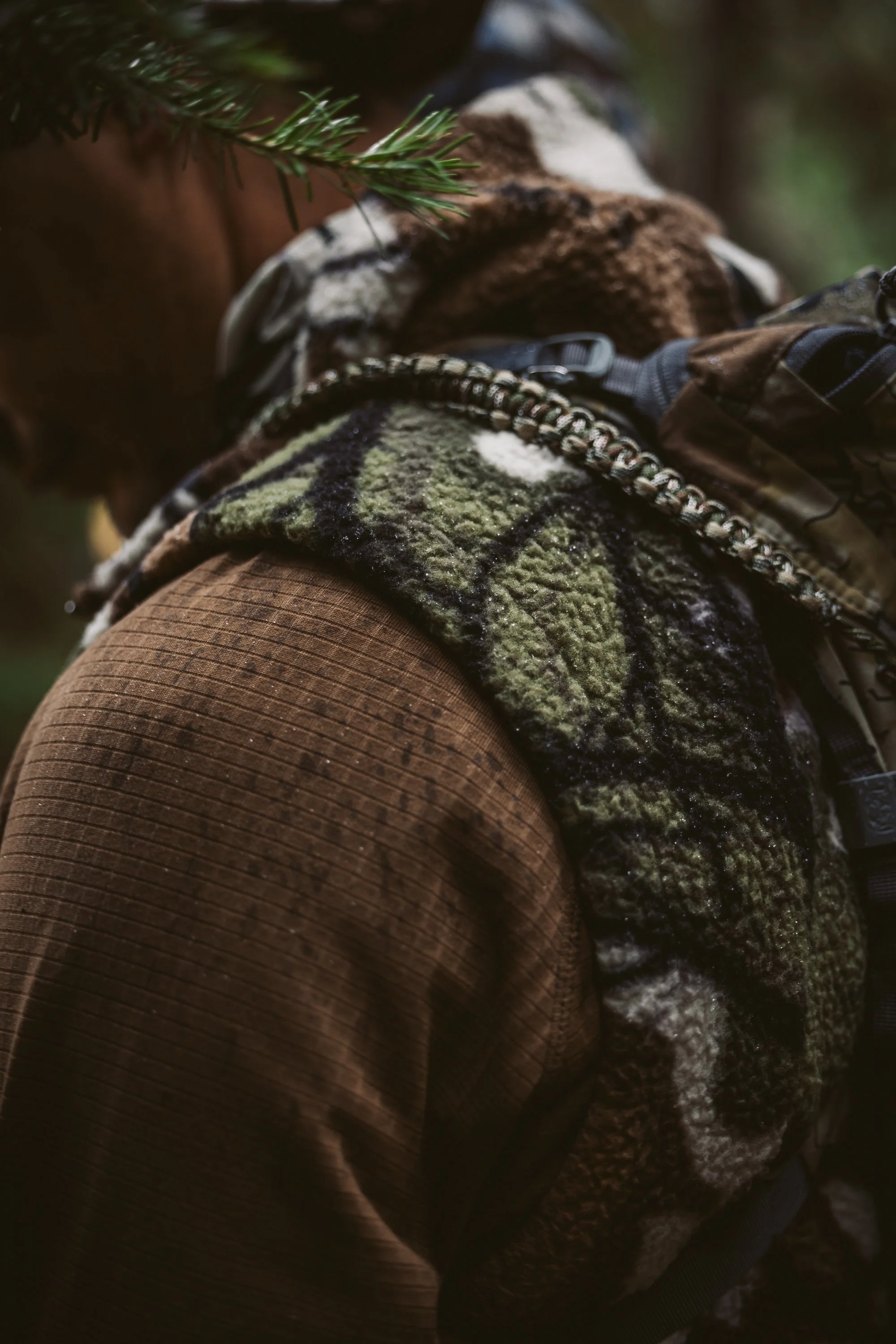 Person wearing camouflage clothing in a forest