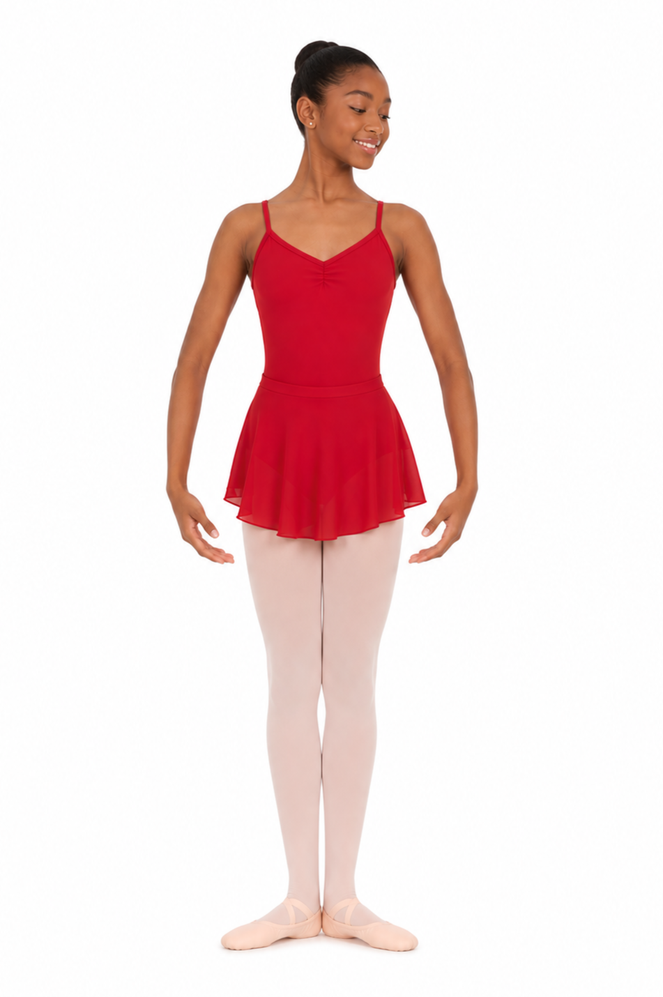 A young girl with light brown hair in a bun, smiling, wearing a light green leotard with spaghetti straps and white tights.