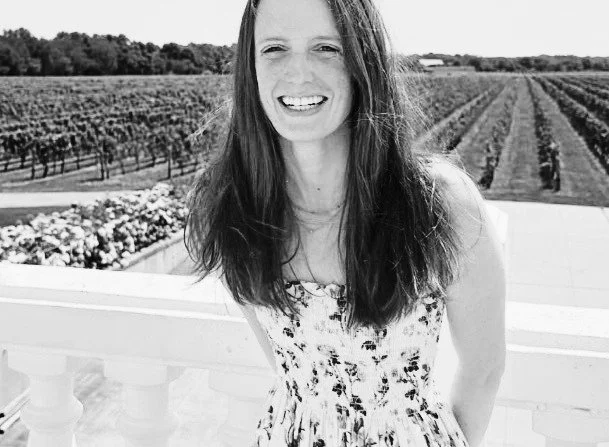 Woman smiling wearing a dress in a vineyard