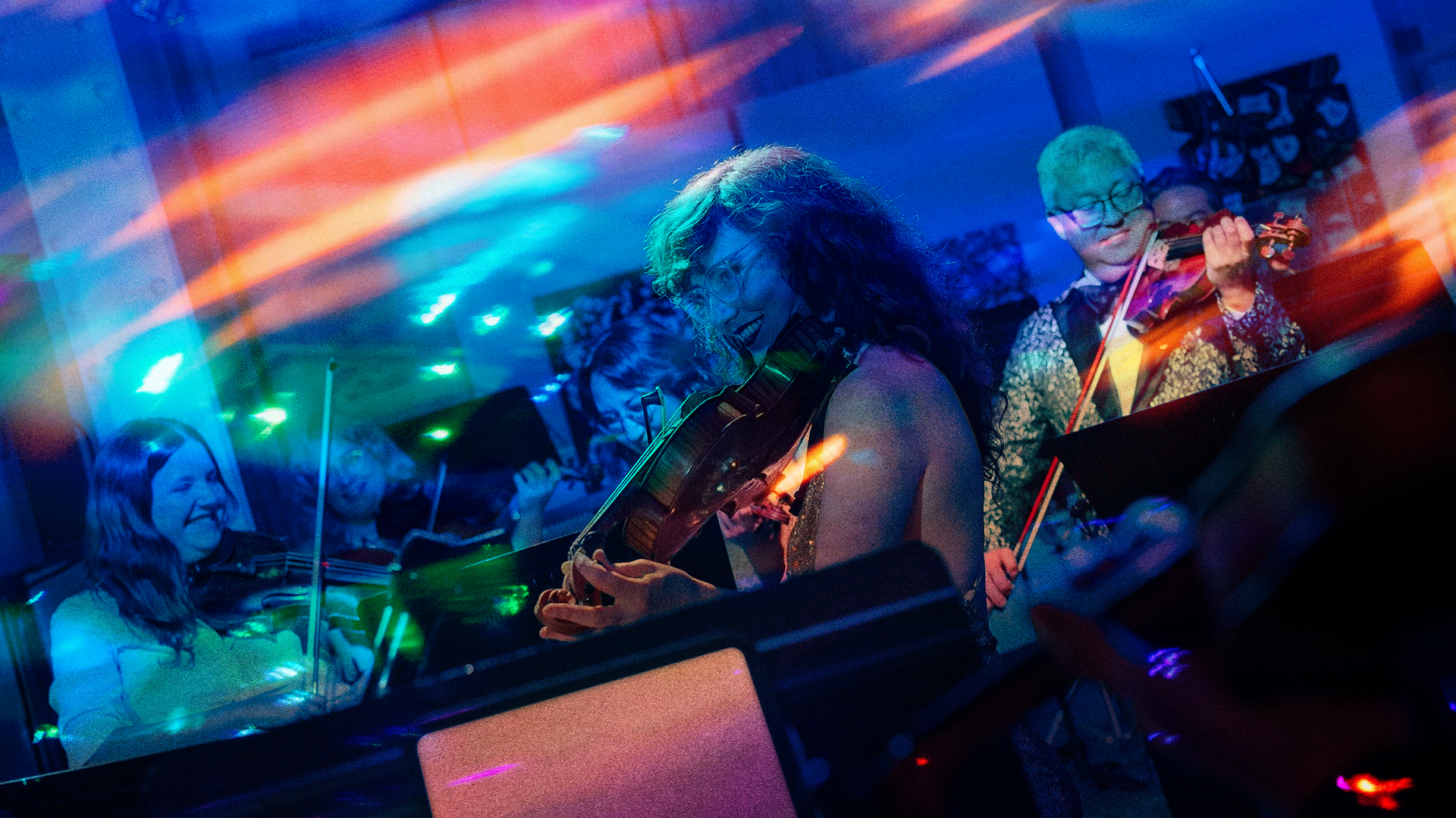 an image of a violist with violinists smiling and performing