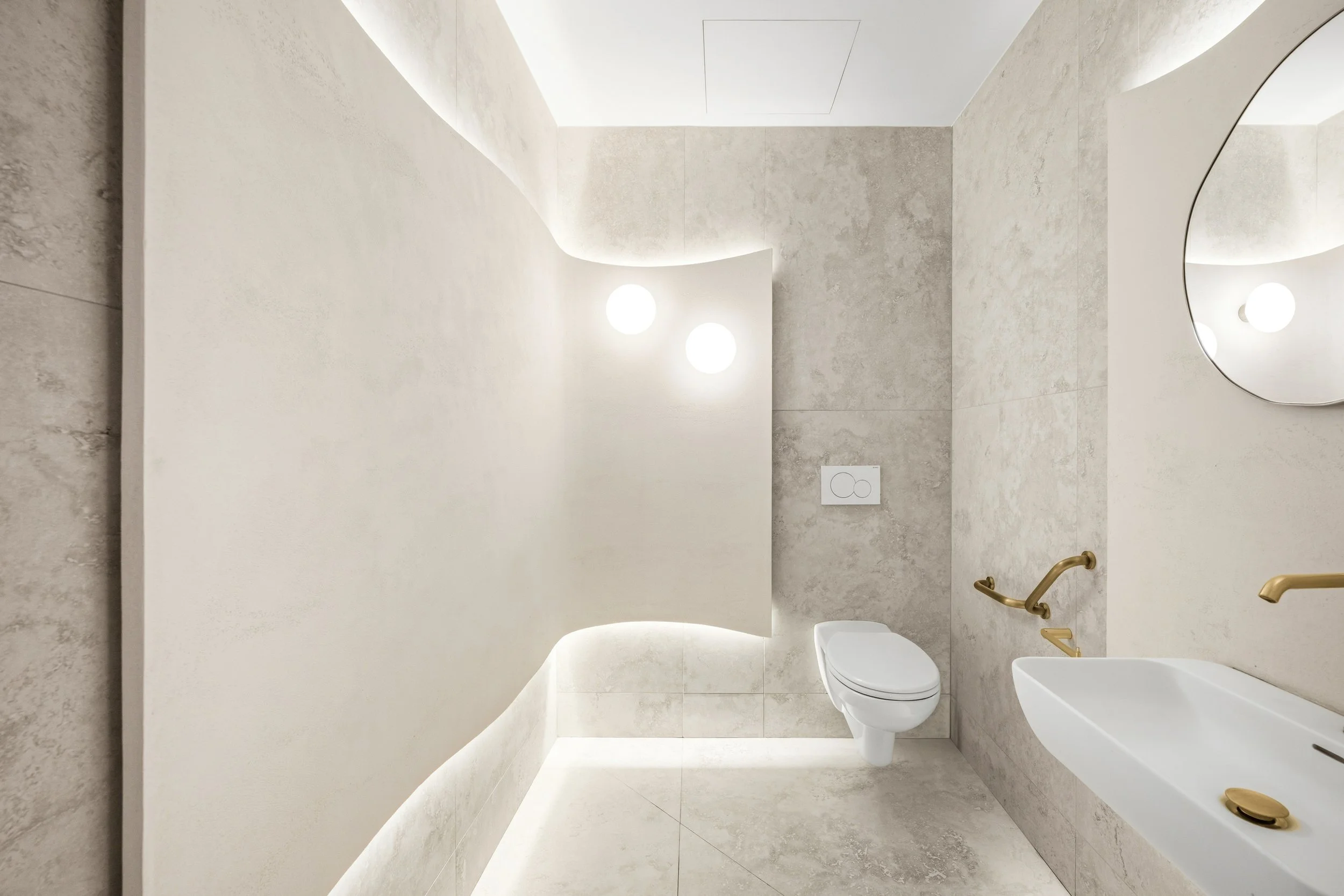 Les sanitaires s’inscrivent pleinement dans l’esprit du projet : leurs courbes organiques, leurs teintes naturelles et leur éclairage étudié avec soin créent un espace à la fois élégant et harmonieux. Chaque détail, du choix des matériaux à l’éclaira