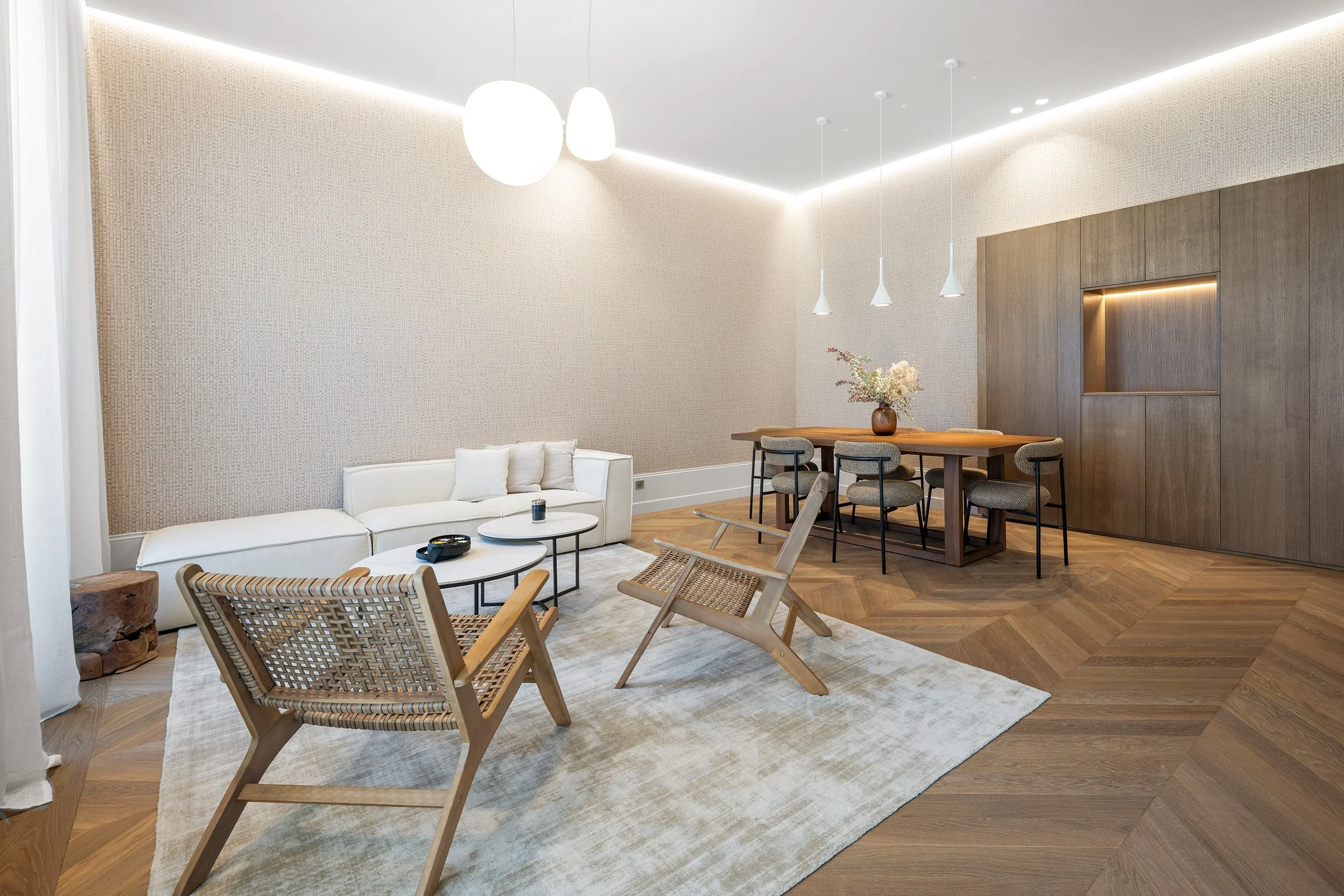 Le salon a fait l’objet d’une attention particulière, notamment sur la conception de son parquet en point de Hongrie, contourné d'une frise et d'un insert en laiton qui sépare la zone cuisine carrelée. Le calepinage des lames et la frise périphérique