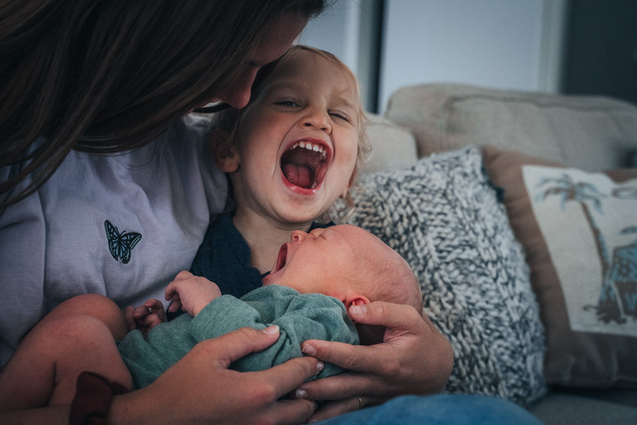 Three year old mimicking his newborn brother crying with a wide open mouth