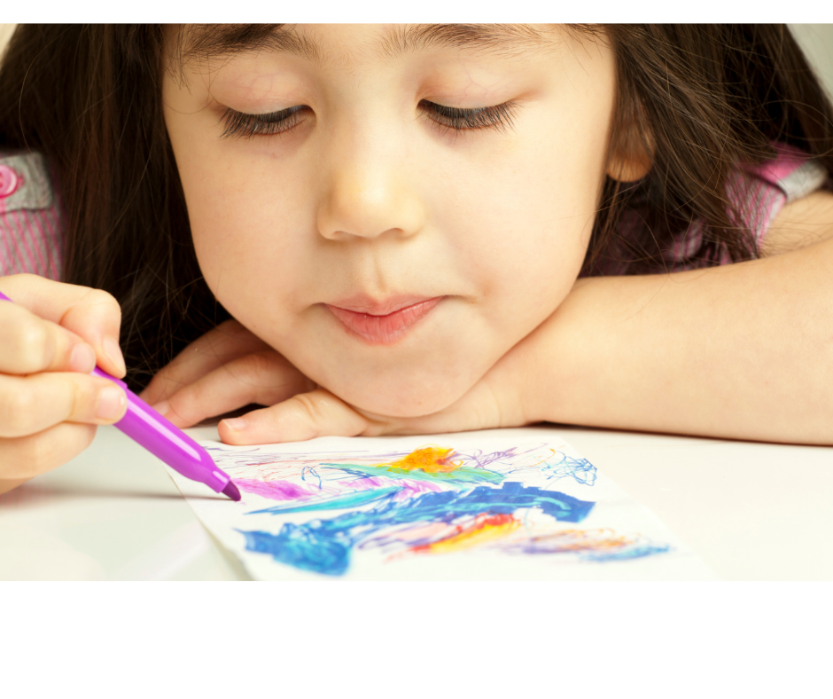 A young girl with long brown hair drawing on a piece of paper with colorful markers.