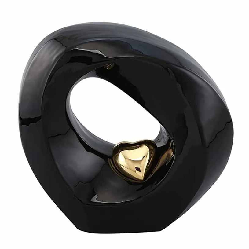 Modern black statue cremation urn for human ashes with small gold heart accent