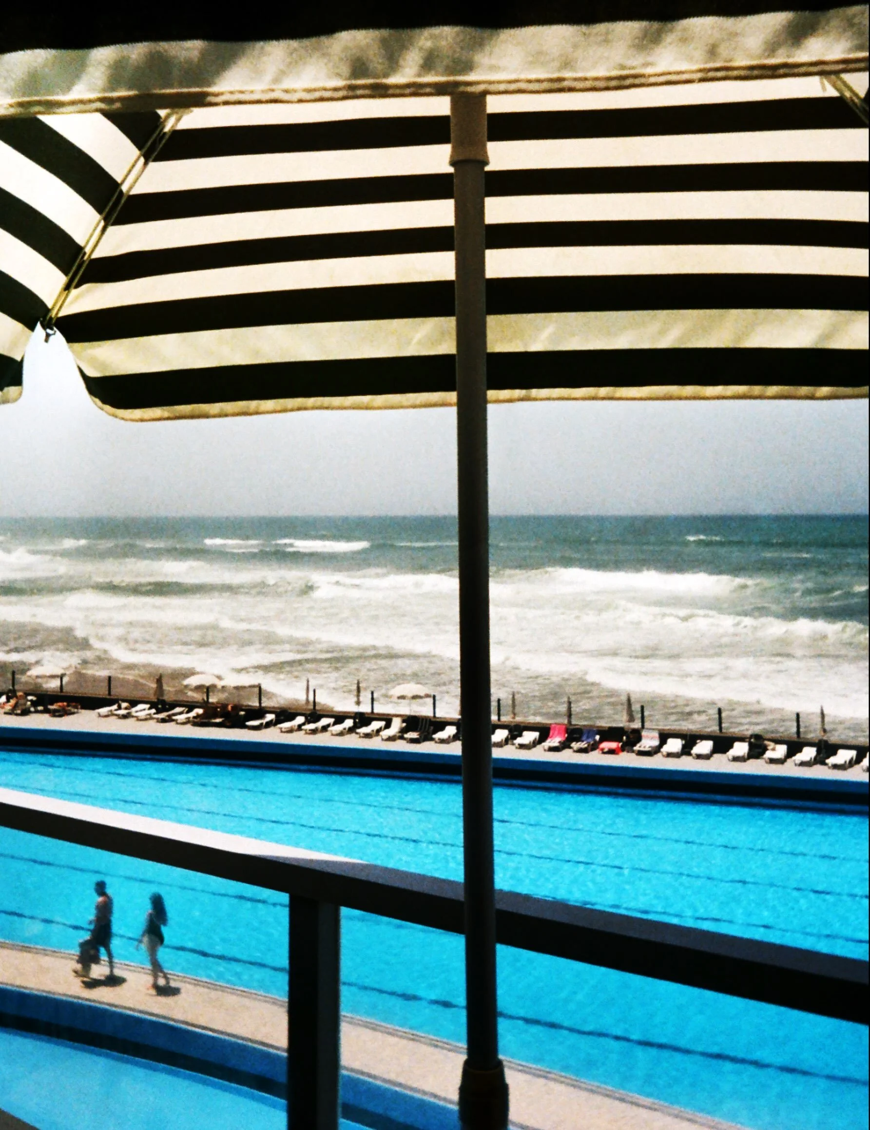 One of my new finished artworks from my travels through Portugal earlier this summer.

I was drawn to the quiet geometry of this moment&mdash;the bold black-and-white stripes of the umbrella, the deep blue of the pool, and beyond it, the restless Atl