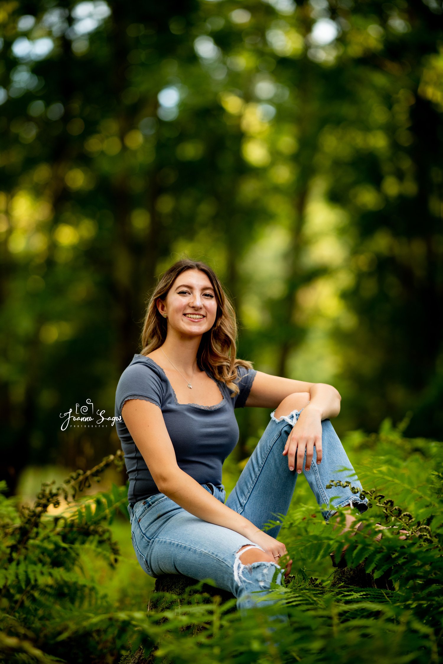 high school senior girl sitting in a field of ferns