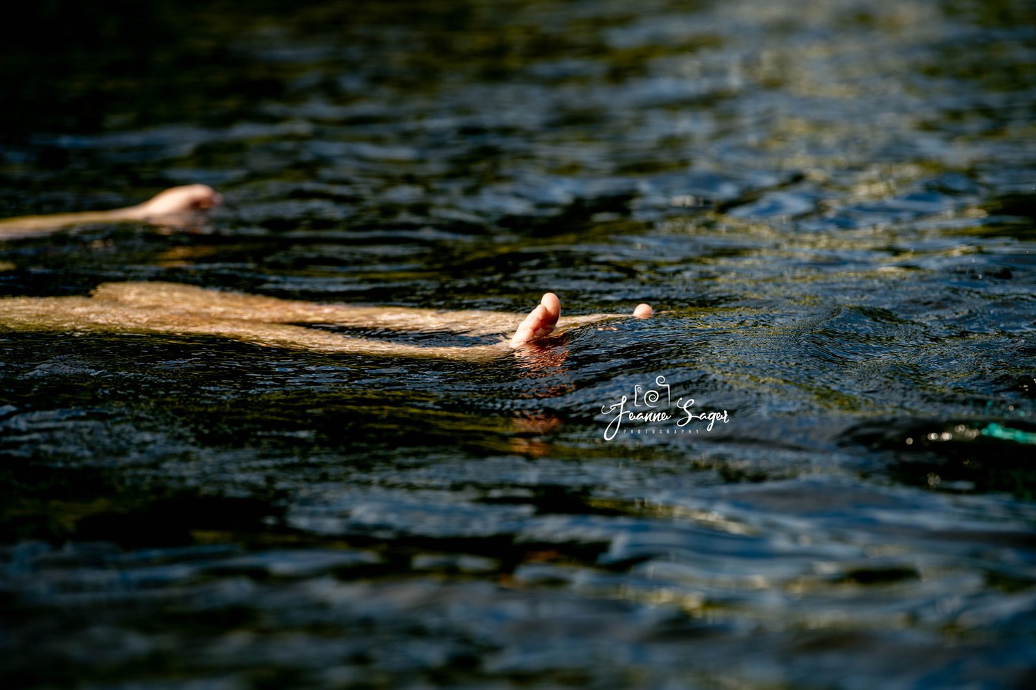 a child floats in the water of the delaware river with their feet poking out of the water