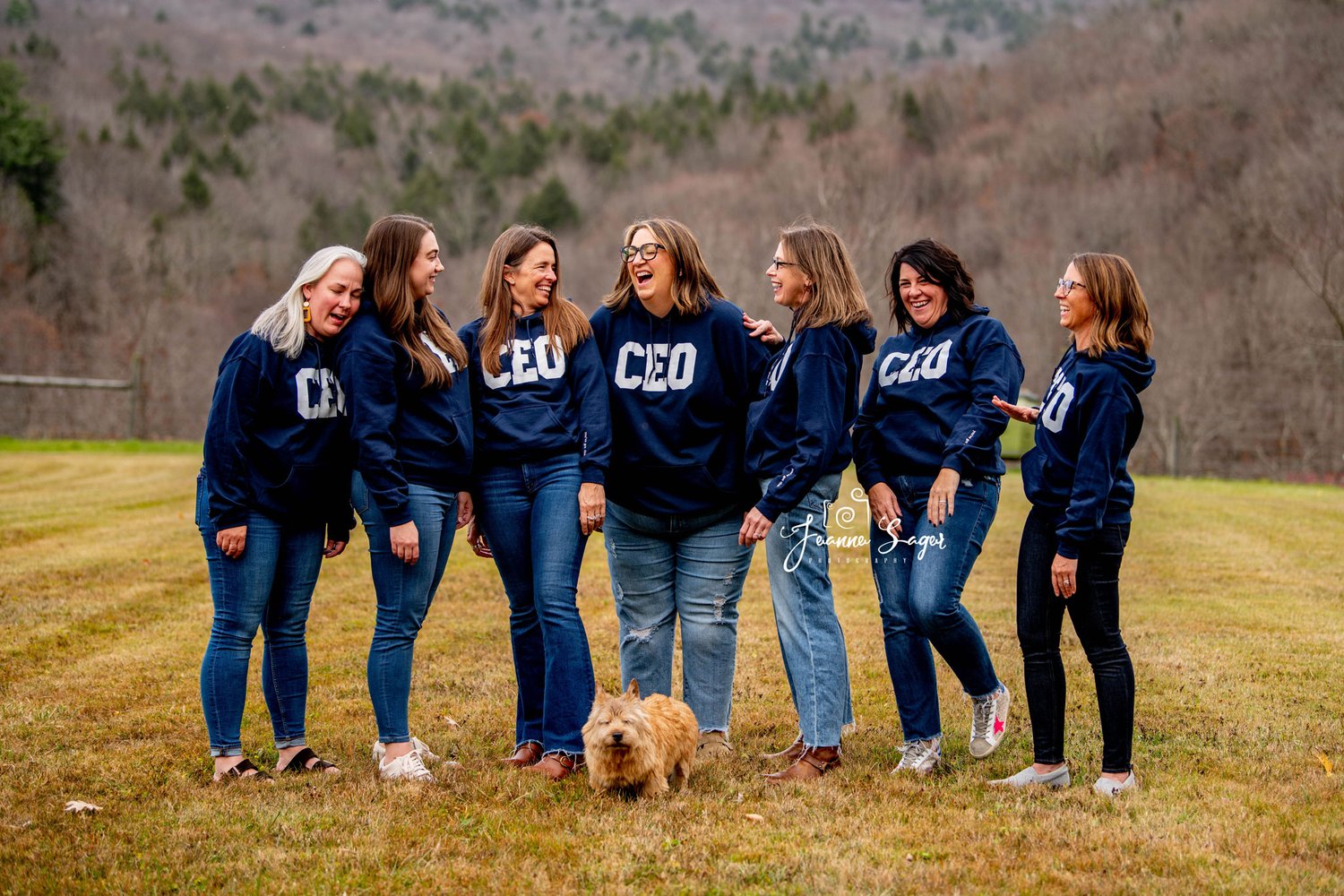 an example of a branding photo for a small business featuring seven women wearing CEO sweatshirts and laughing together