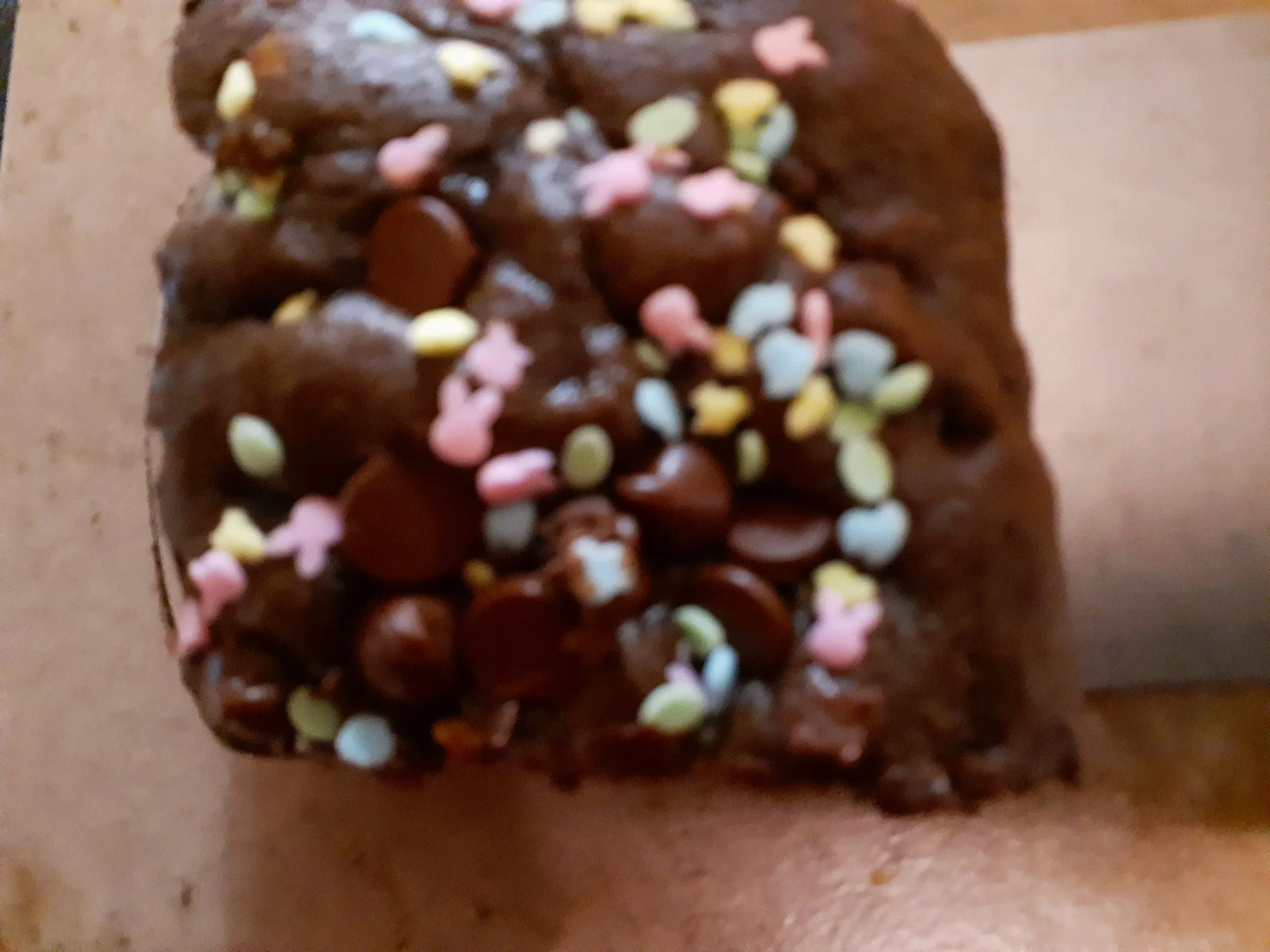 Close-up of a brownie with heart shaped sprinkles.
