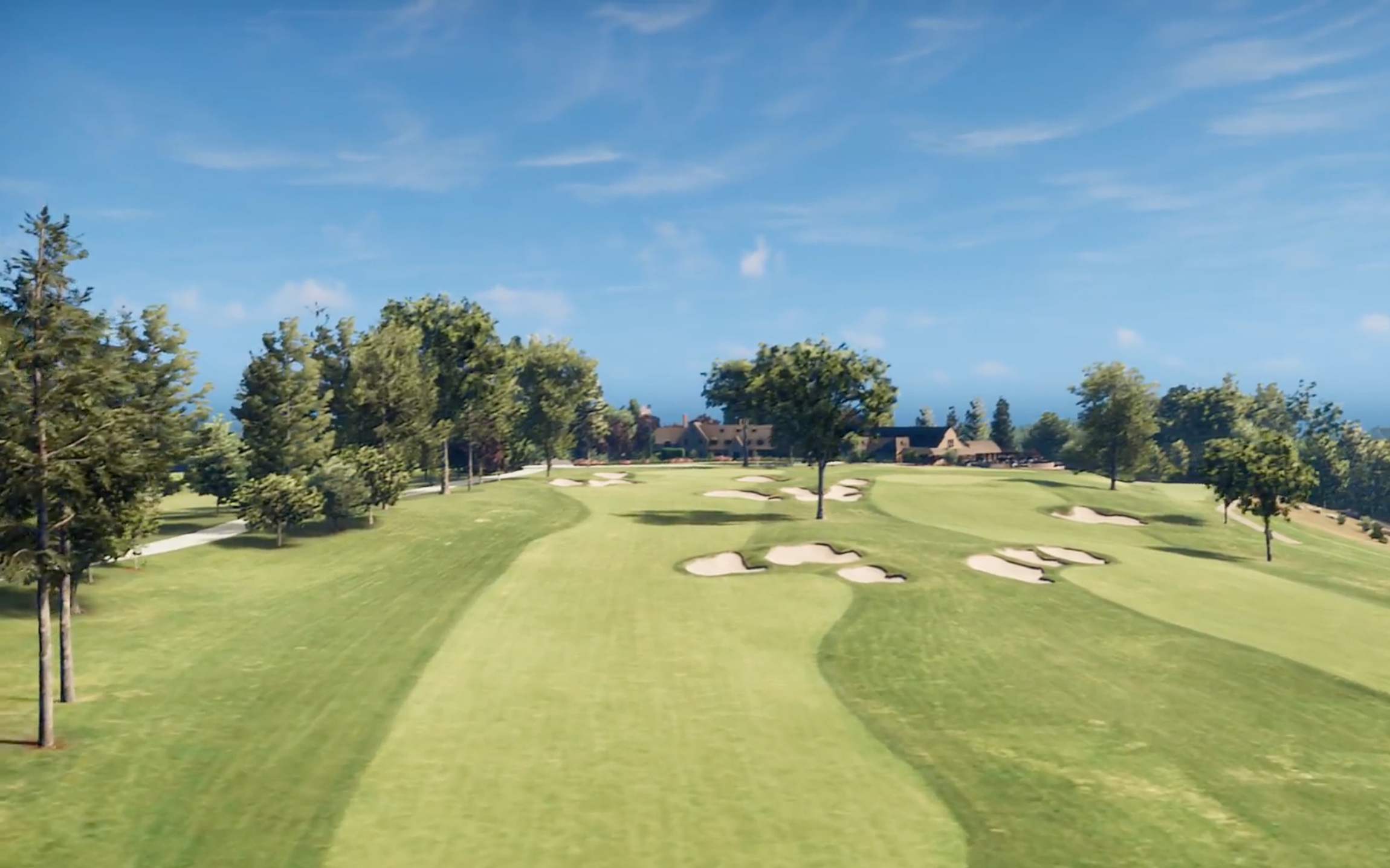 A golf course with green fairways, sand bunkers, a water hazard, and a walking path under a partly cloudy sky.