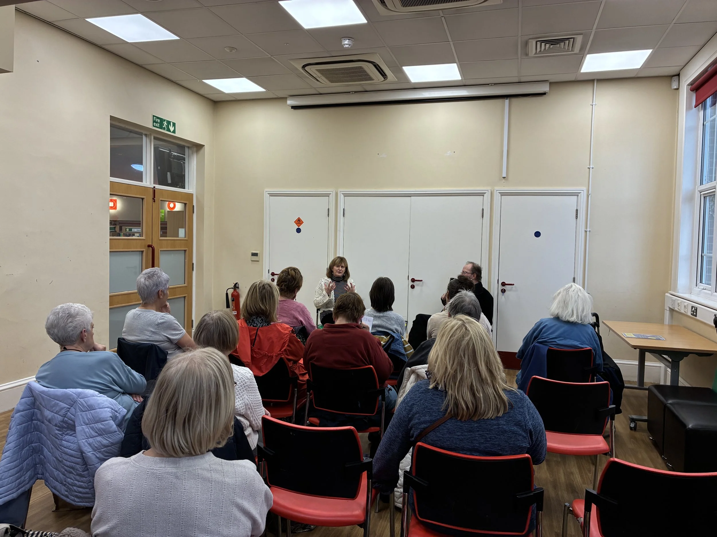 An author talking to a group of people in a library setting.