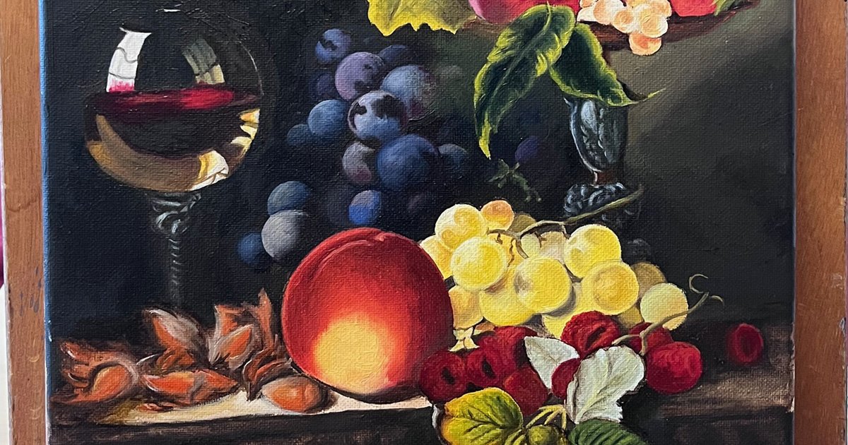 Finished oil painting on a table top easel of a wine glass with red wine alongside various fruits, nuts and leaves.