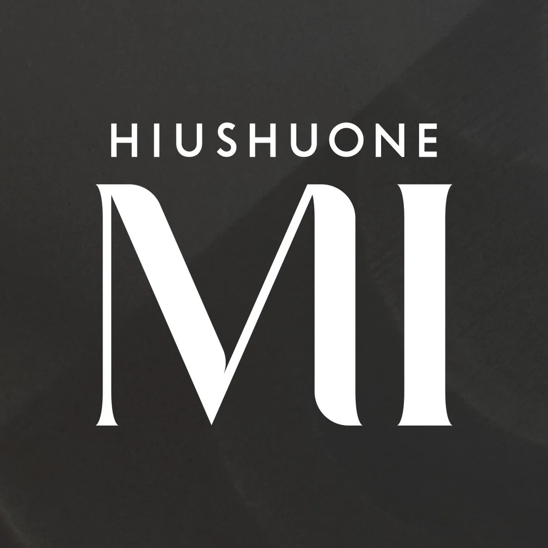 Logo Hiushuone MI. Hiushuone MI on Lahden keskustassa toimiva parturi-kampaamo. Logon suunnittelu logosuunnittelija Niina Behm, mainostoimisto Studio Behm.