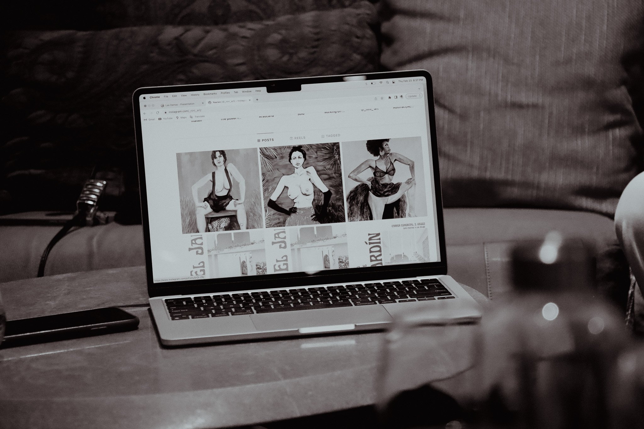 Laptop on table displaying a website with fashion photography.