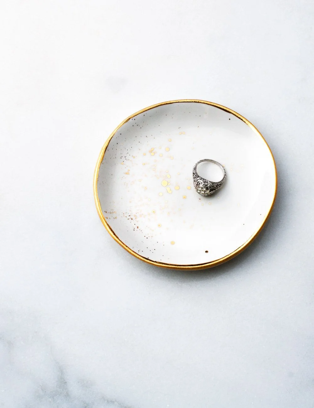suite-one-studio-ring-dish-in-white-with-gold-splatters-and-engagement-ring_48df0f55-c297-4220-a275-b237589a7d3a.jpg
