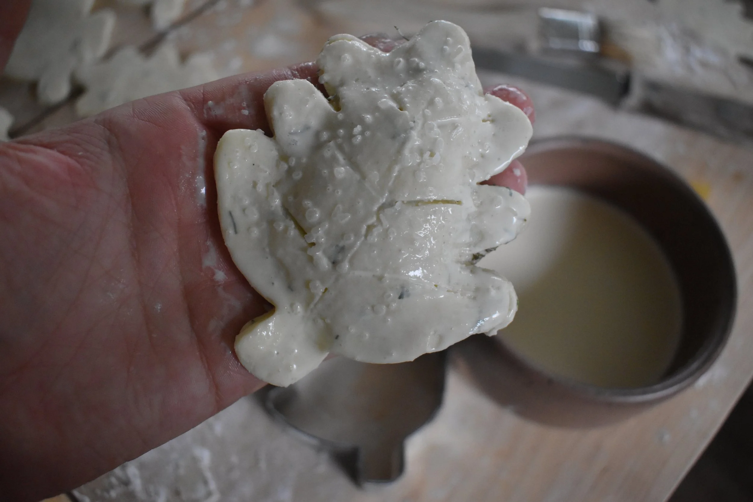  A hand holds an uncooked pie shaped like a leaf 