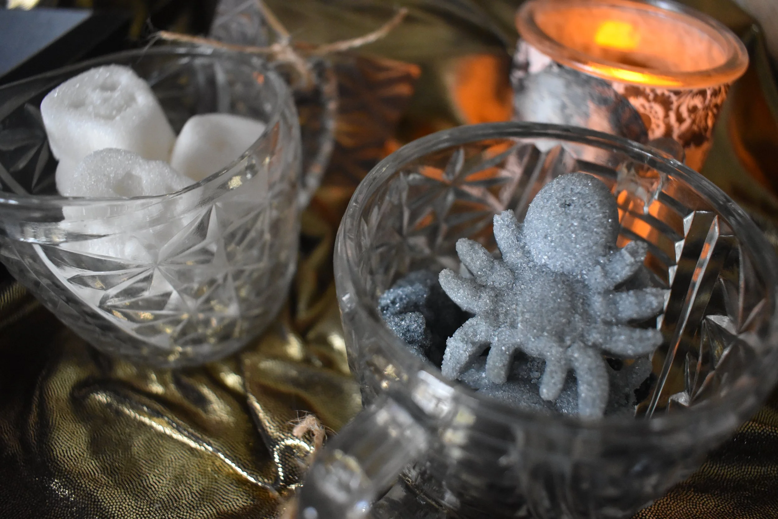 Sugar molded into gray spiders and smiling skulls in glass jars