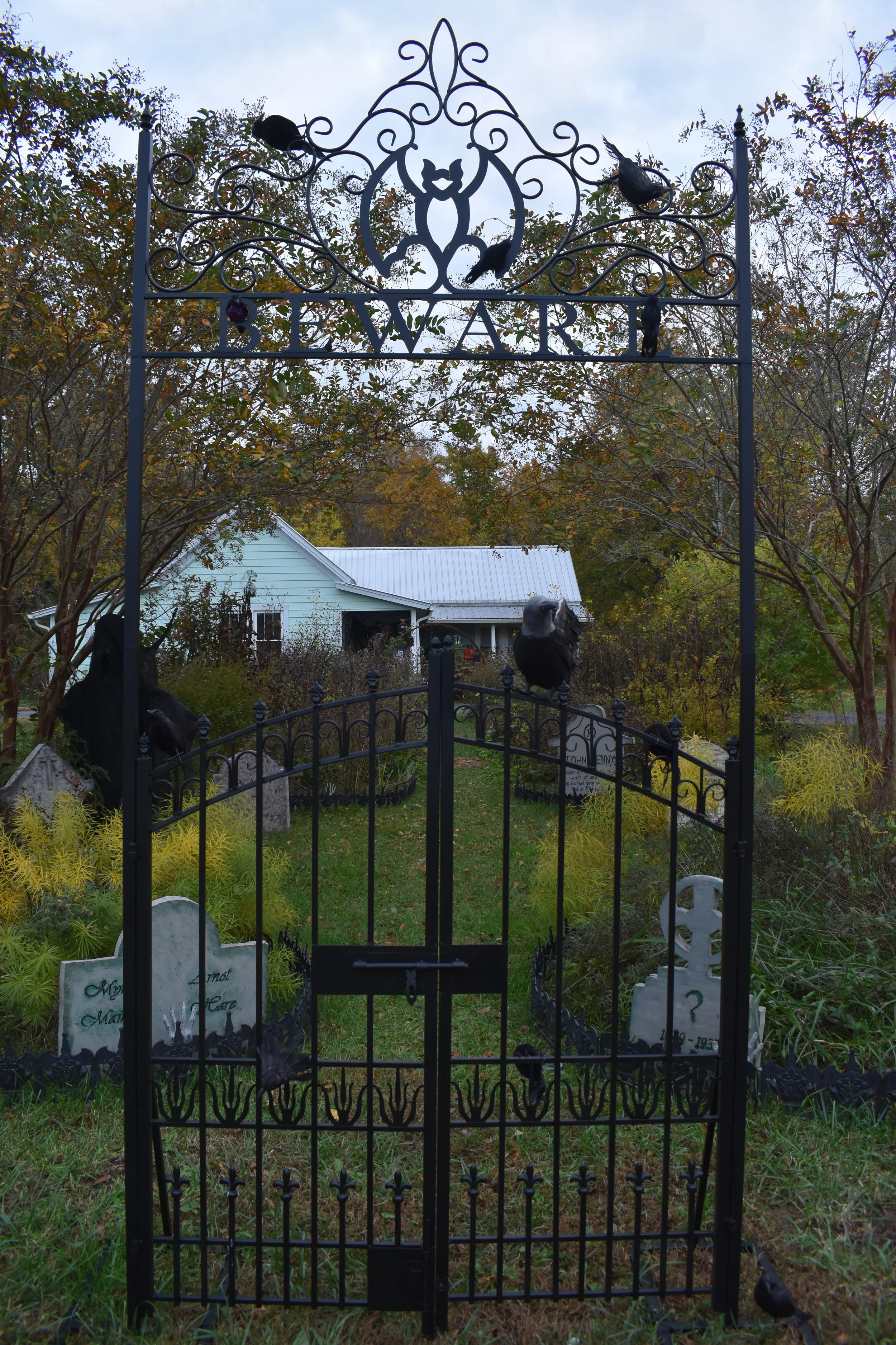 metal garden gate in front of a farmhouse
