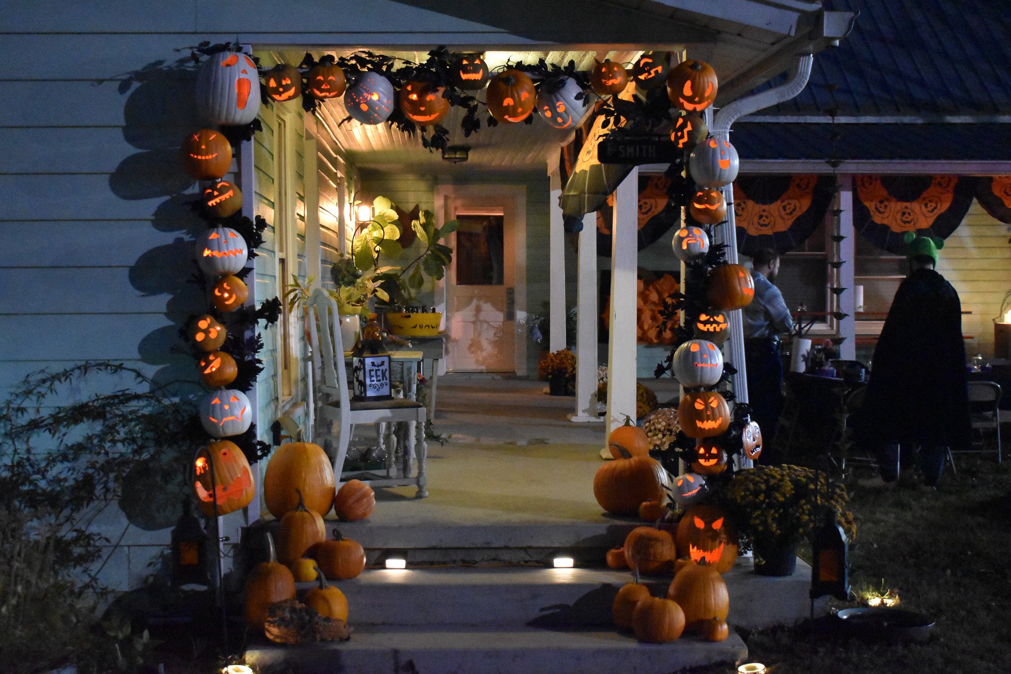 a porch entry with an arch made of jack-o-lanterns