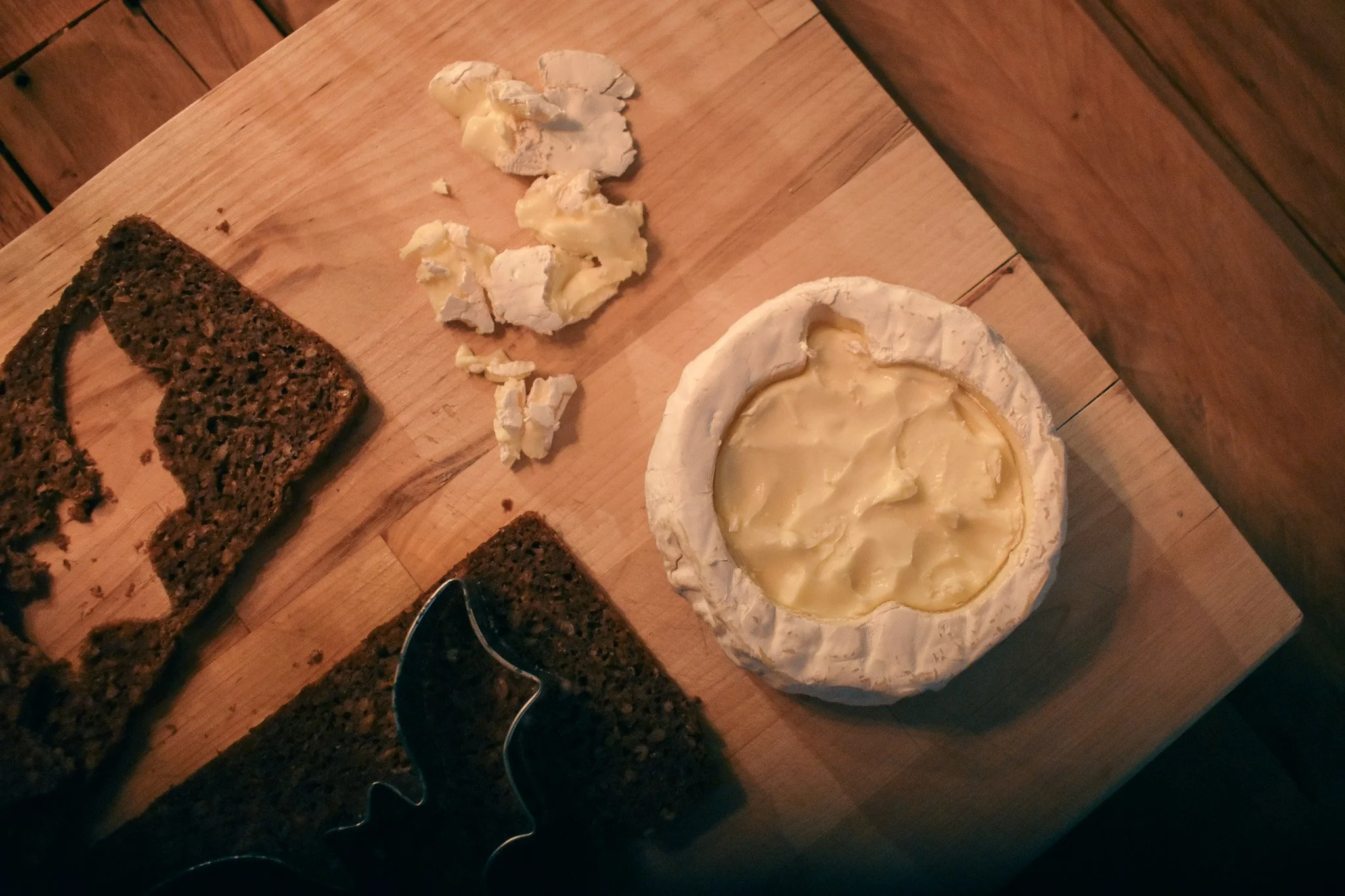wheel of brie with a pumpkin shape scraped out of the center