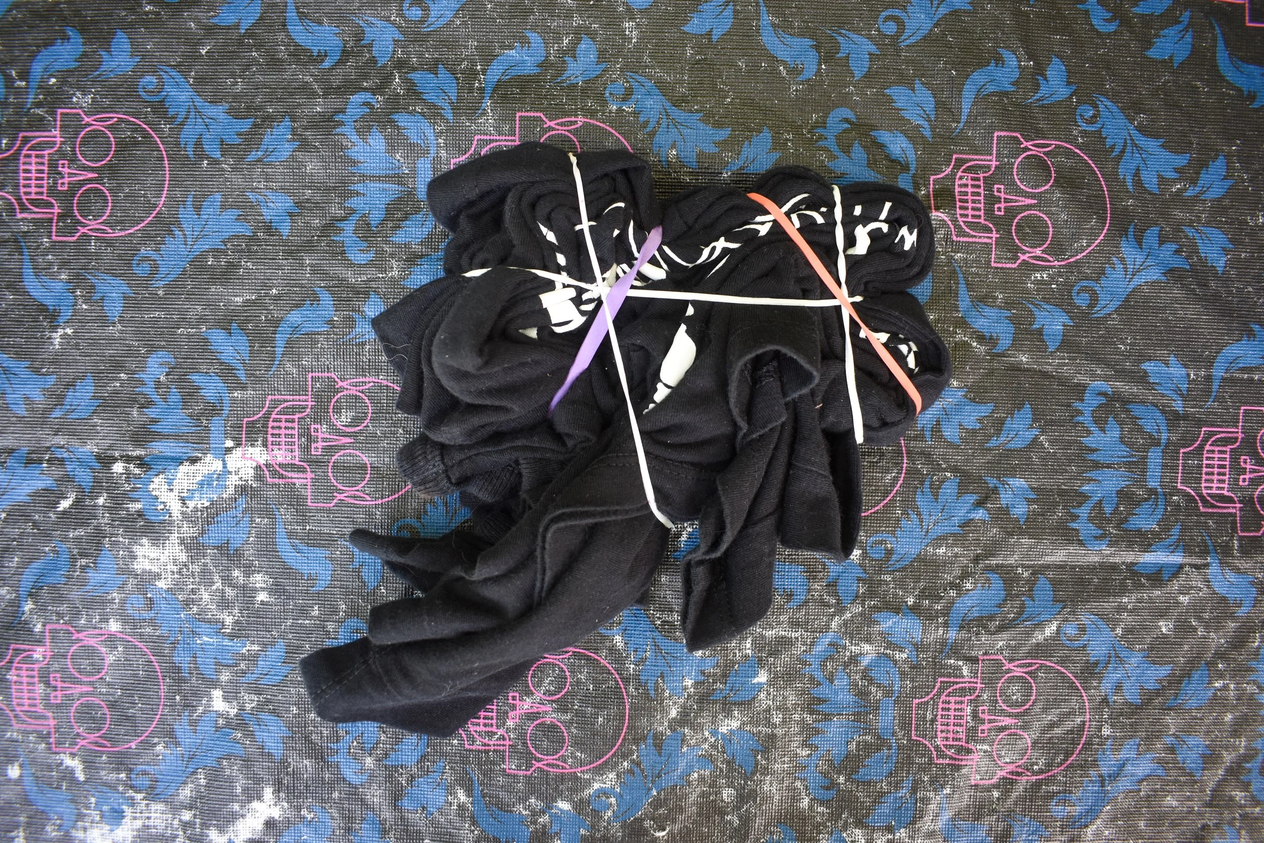 overhead image of a shirt twirled into a spiral and wrapped in rubber bands