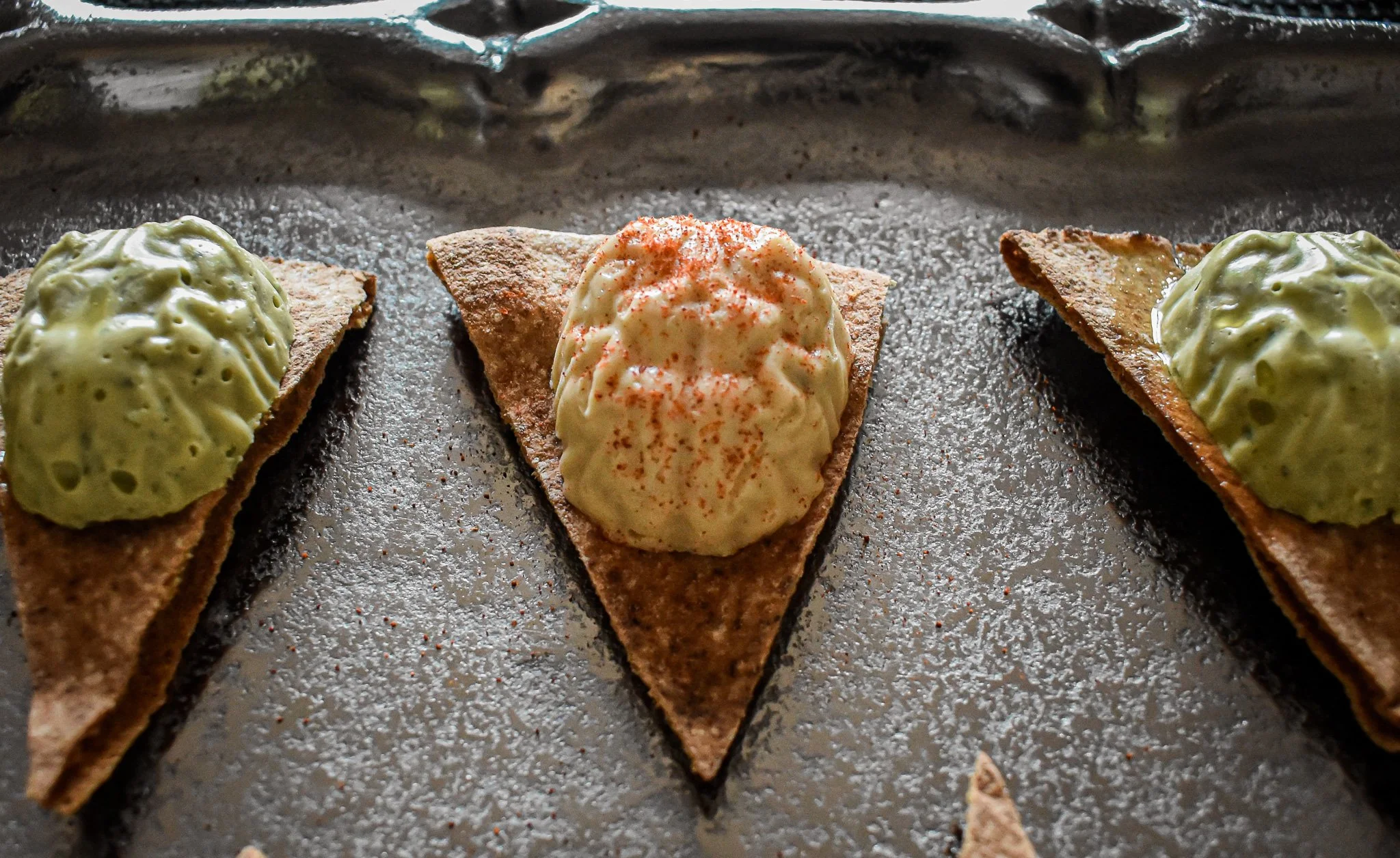 closeup of hummus brains on pita triangles