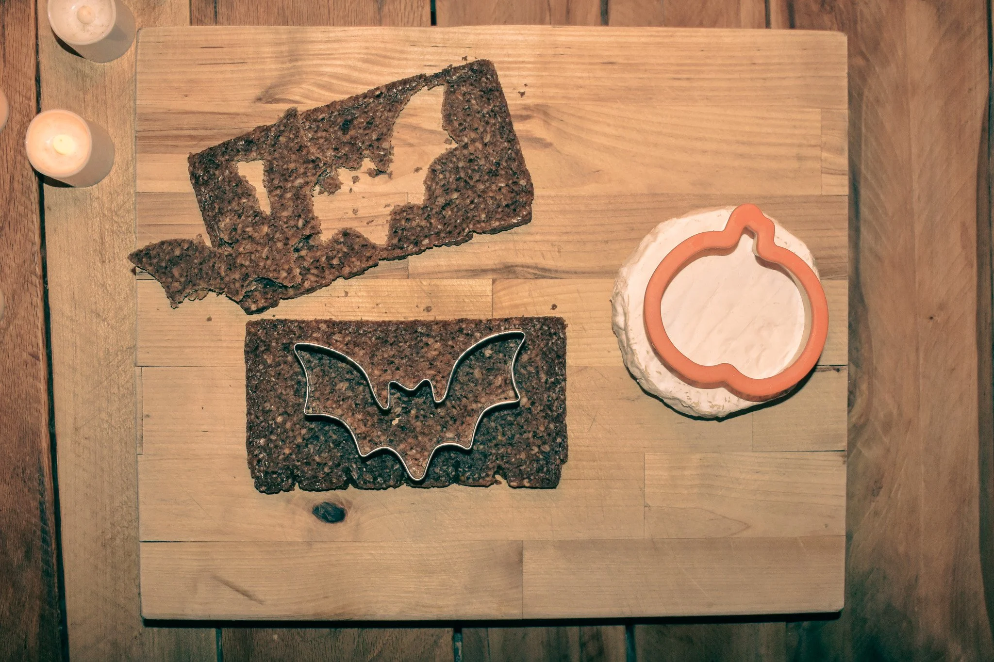 cutting board with bread, cheese, and cookie cutters