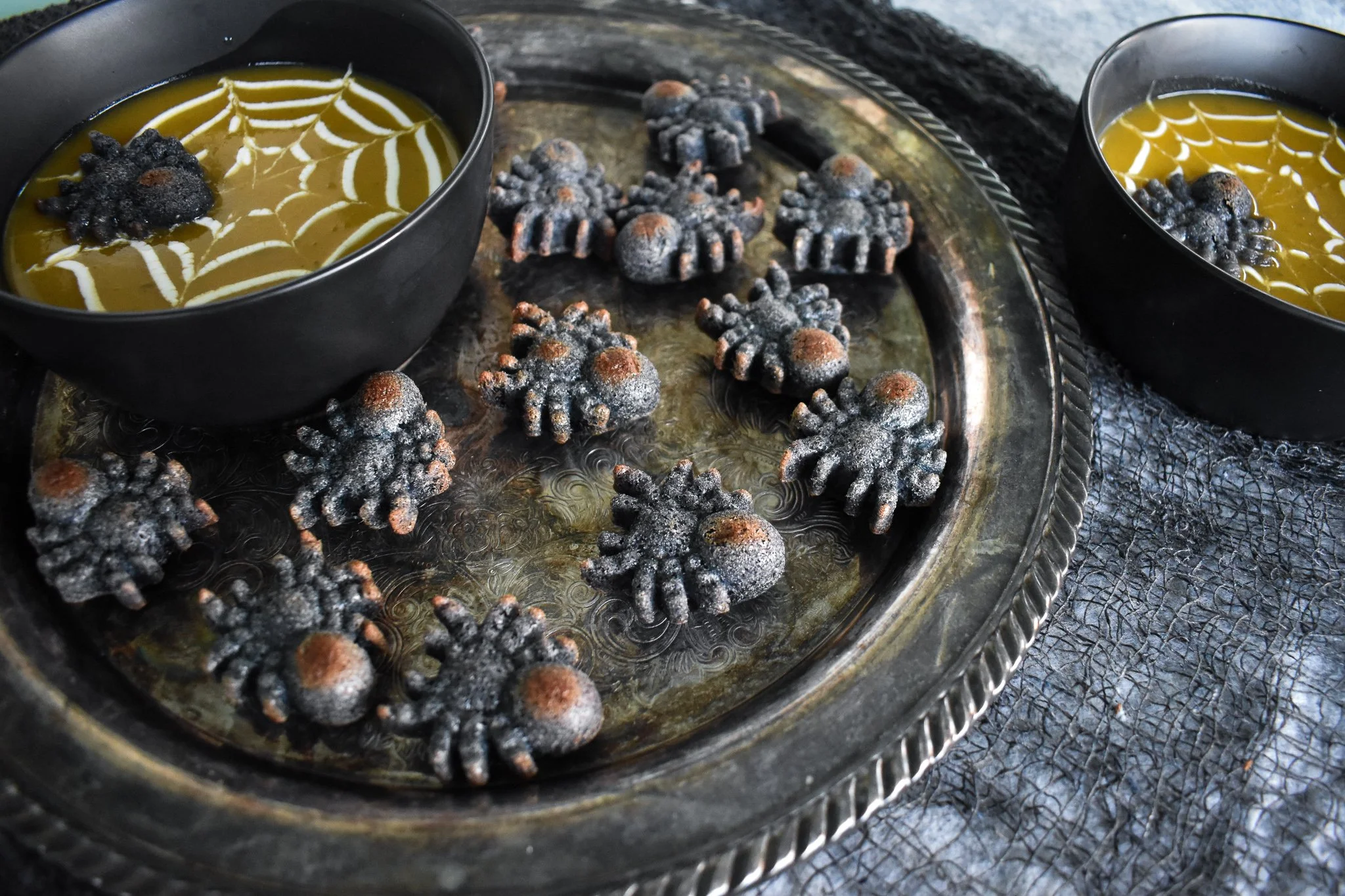 Silver platter with blue cornbread spiders and two bowls of soup
