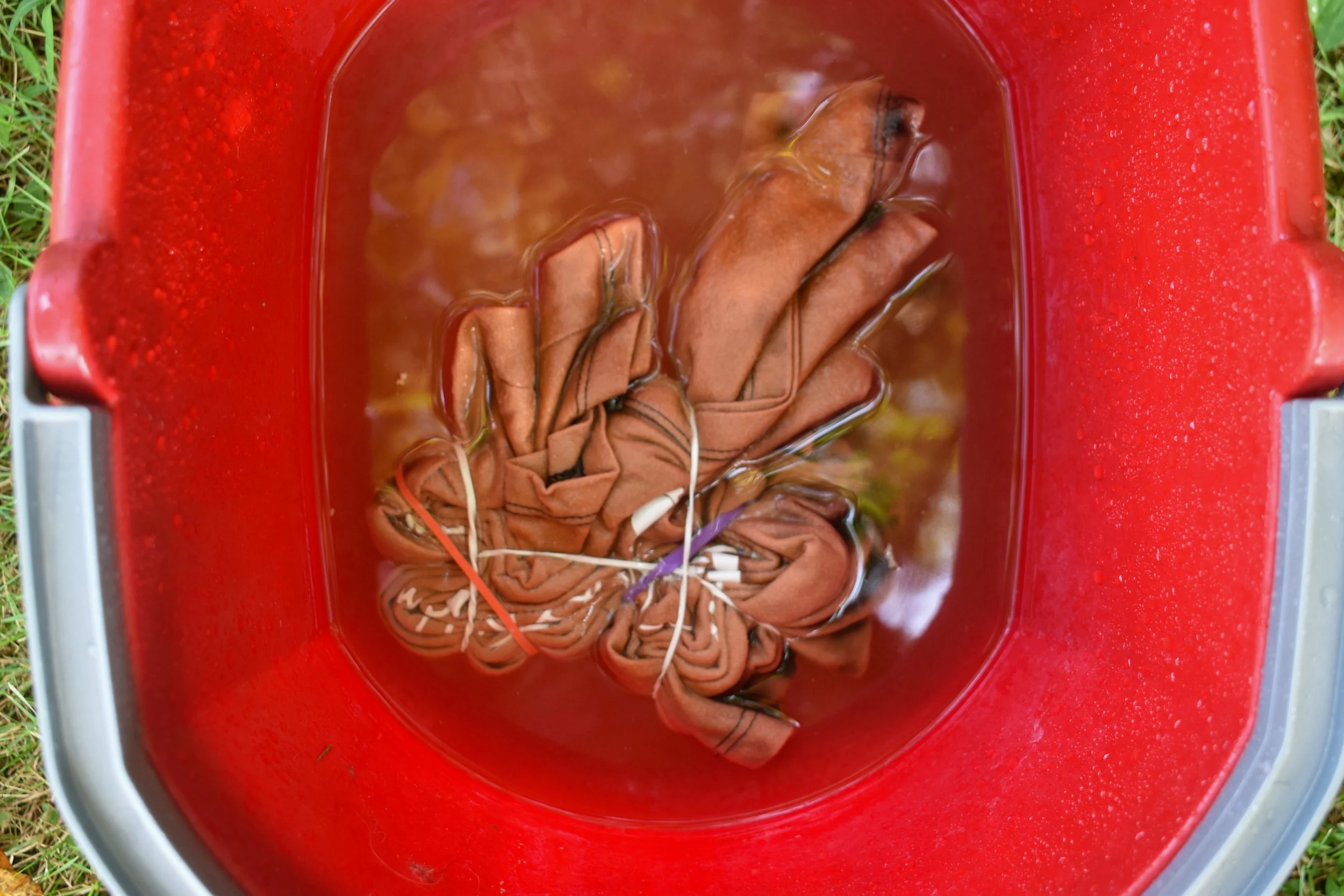 overhead image of a shirt in a bucket of water and hydrogen peroxide