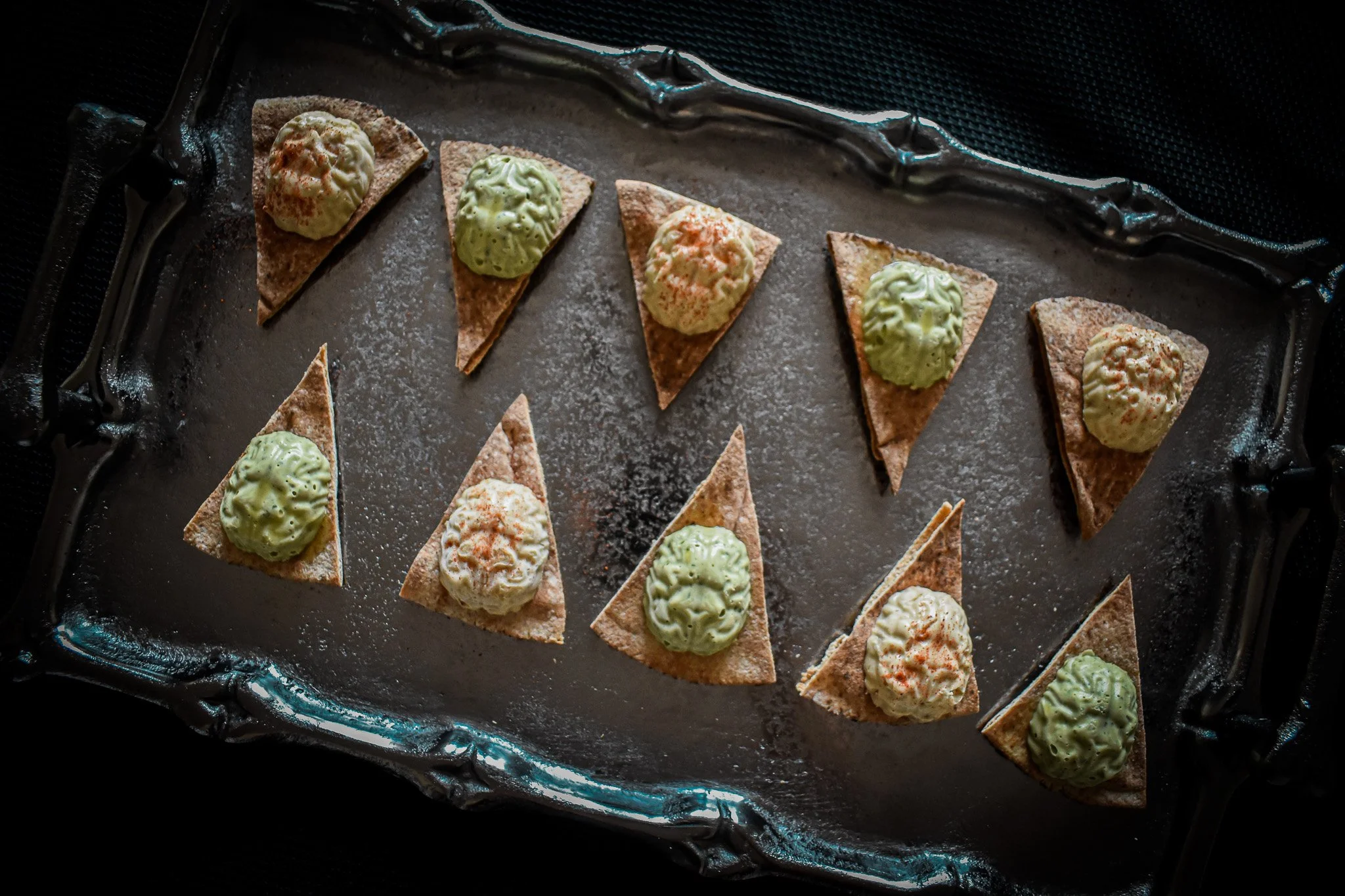 Brain shaped hummus on pita tringles