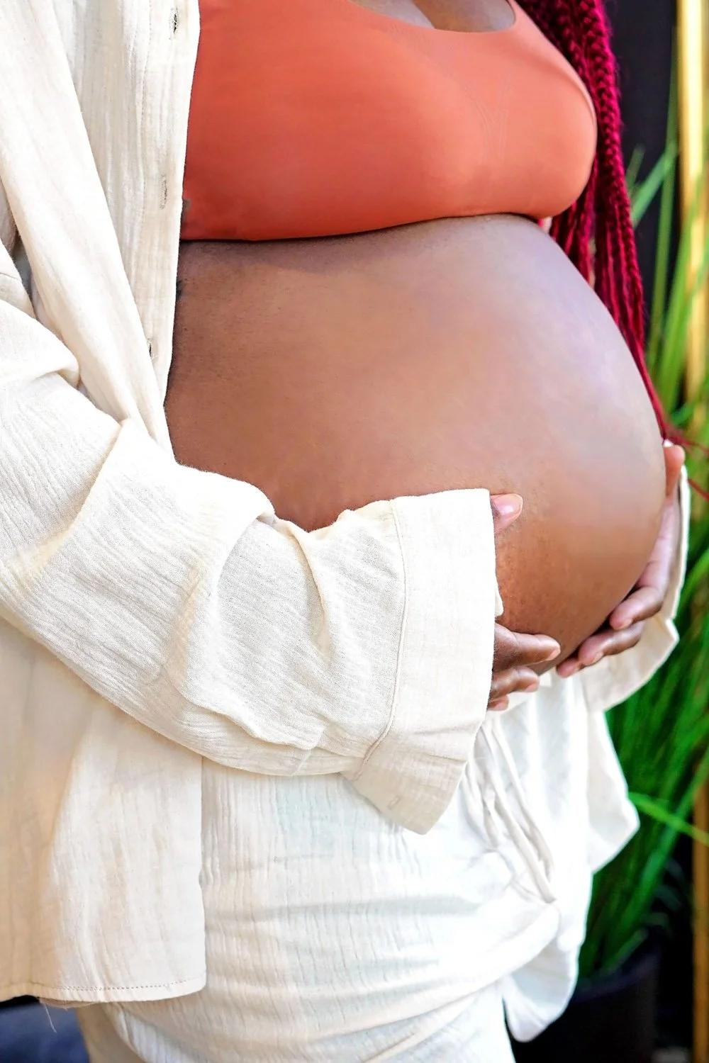Pregnant woman gently holding her belly.