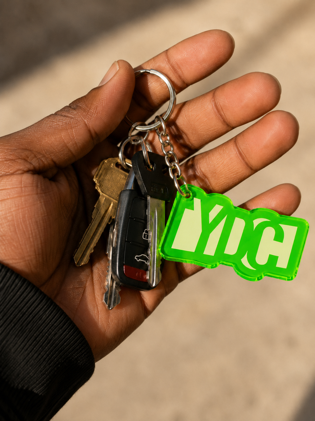 Green acrylic Youth Design Center logo keychain with silver key ring