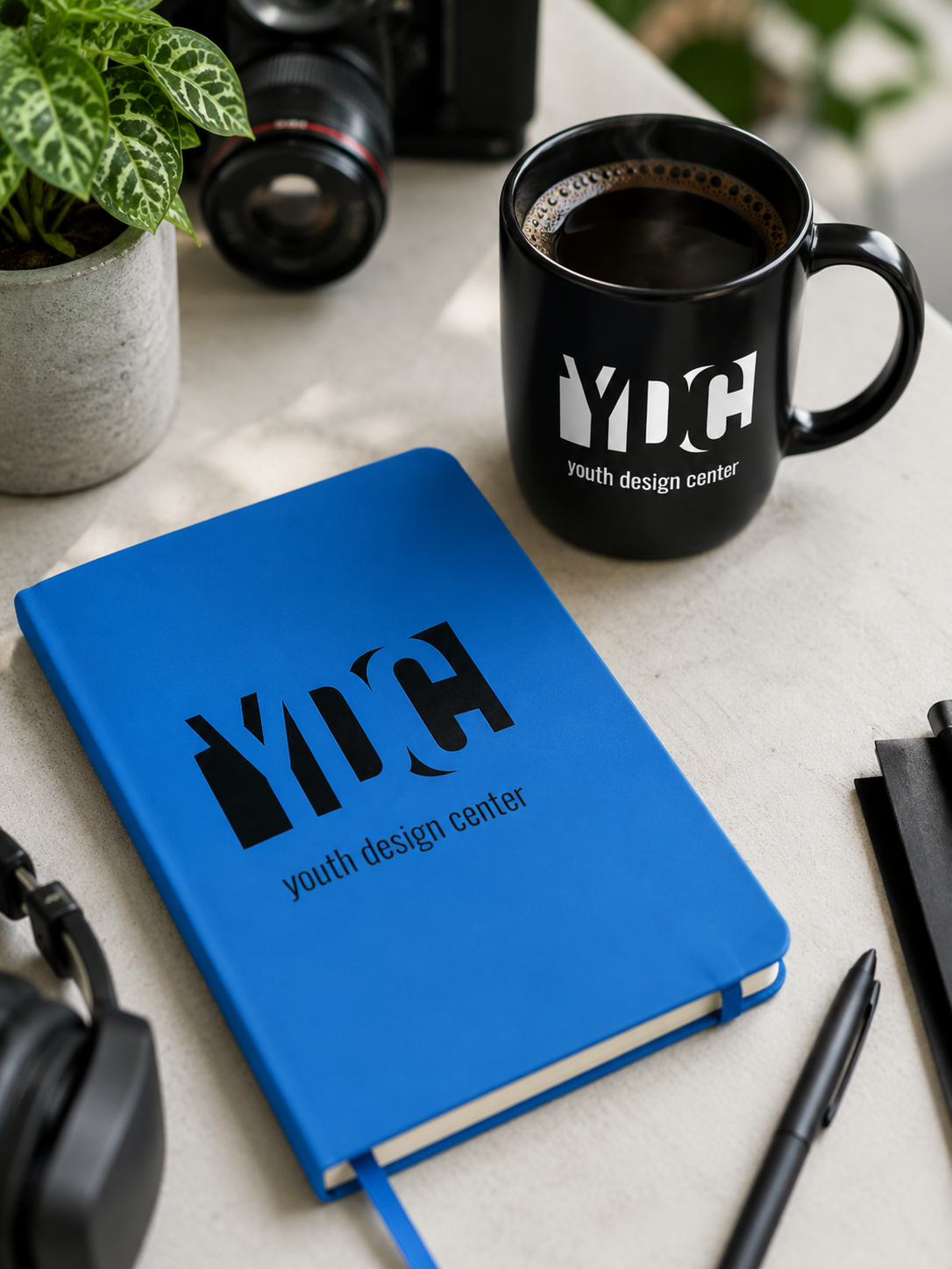 Blue notebook featuring the black Youth Design Center logo on the cover