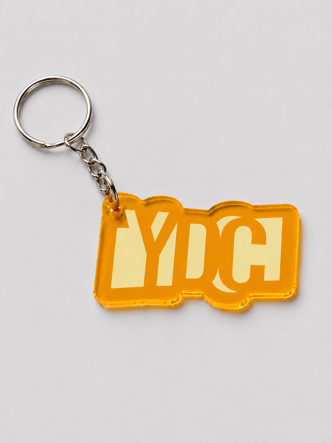 Orange acrylic Youth Design Center logo keychain with silver key ring