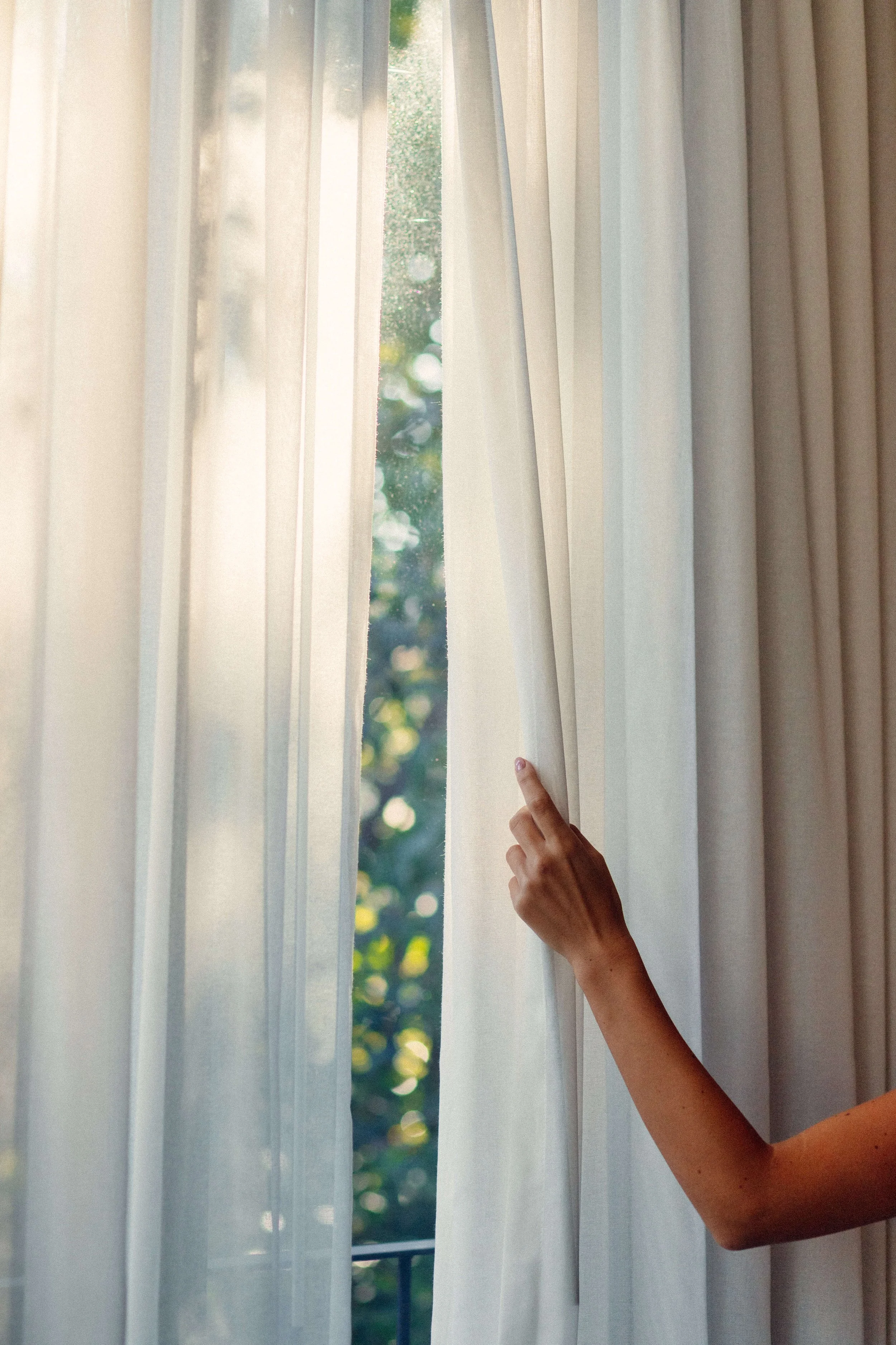 Close-up of a swimming pool with reflections of a metal fence and sky on the water surface, next to wooden poolside decking.